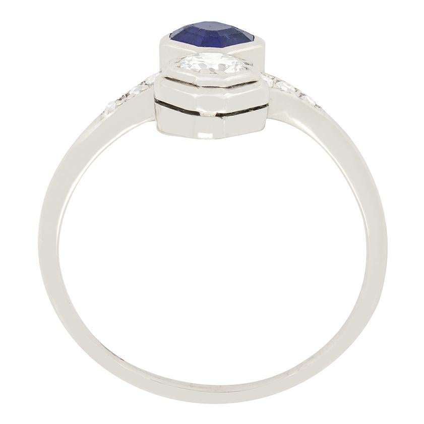 Dating back to c.1930s is this two stone twist ring crafted in 18ct white gold. It features one 0.30 carat transitional cut diamond and set adjacent is one 0.50 carat asscher cut sapphire. The diamond has been estimated as F in colour, VS1 in