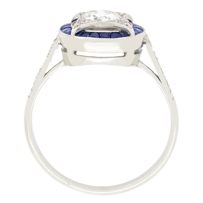Hand crafted in the 1930s, here we have a stunning diamond and sapphire target ring. The central 0.55 carat transitional cut stone sits within a four pointed star shaped mount and is encircled by a halo of French cut sapphires, totalling 0.63 carat.
