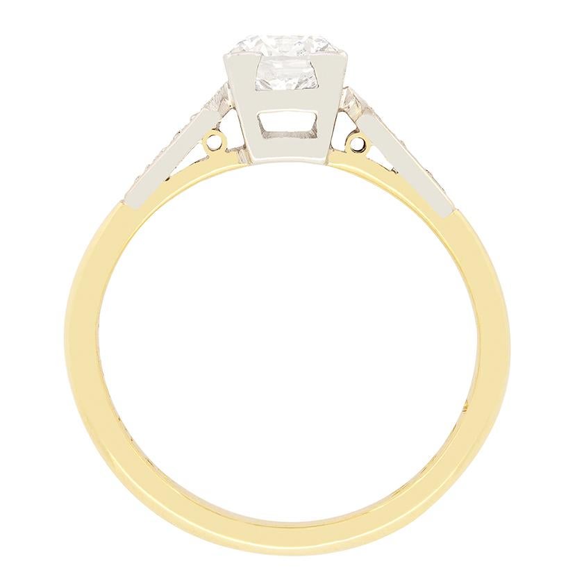 Classic in it’s design, this  is this Late Deco solitaire features a 0.70 carat round brilliant diamond. The diamond has been graded as an F in colour and SI2 in clarity and has been corner claw set in a square platinum collet. A further three 0.01
