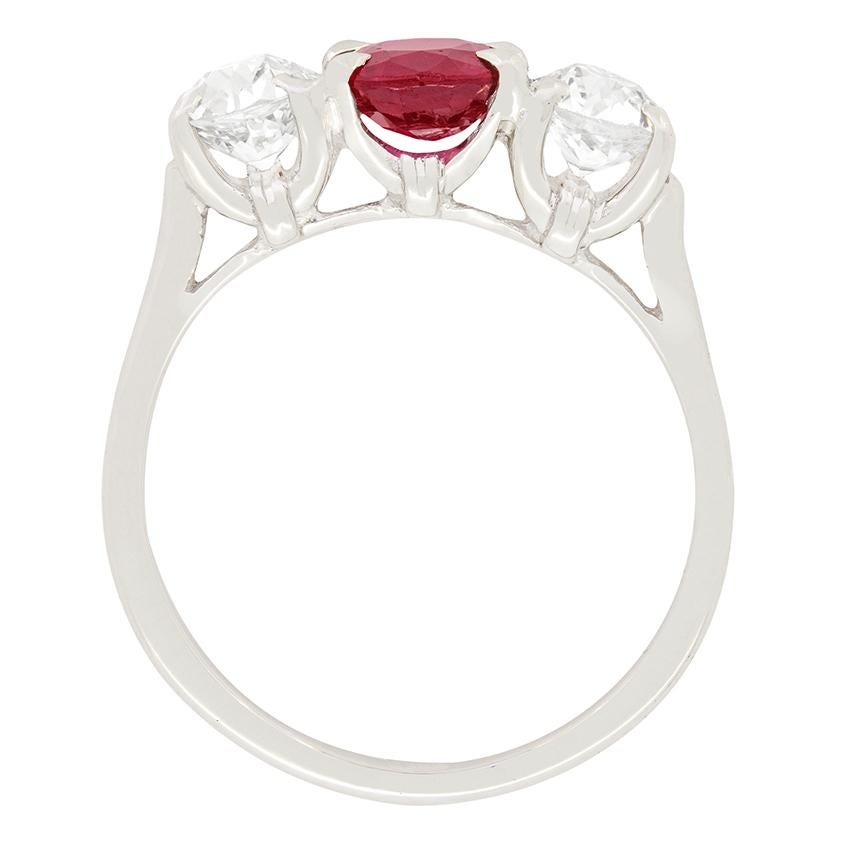 A natural, unenhanced ruby proudly stands out in this 18ct white gold three stone ring. The stunning ruby has a carat weight of 0.85 and is cushion in shape. Contrasting either side are a pair of sparkling old cut diamonds which have a combined