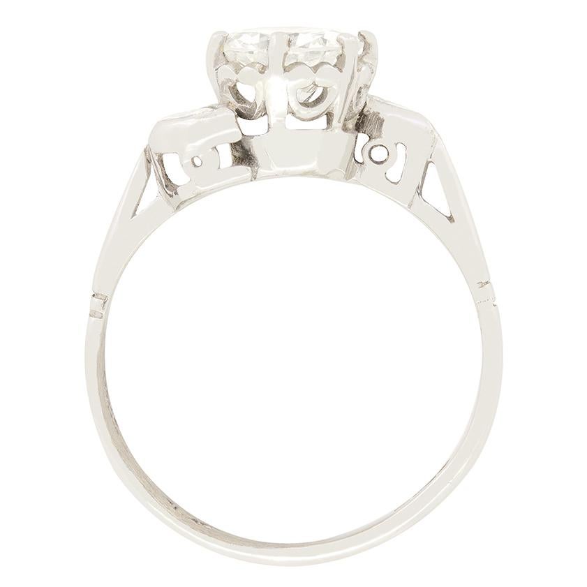 Dieser atemberaubende Solitärring im Spätdeko-Stil präsentiert in seiner Mitte einen Diamanten im Übergangsschliff mit 0,90 Karat. Der zentrale Stein ist in Platin gefasst und wird von zwei Diamanten im Marquiseschliff (0,05 ct) flankiert, die auf
