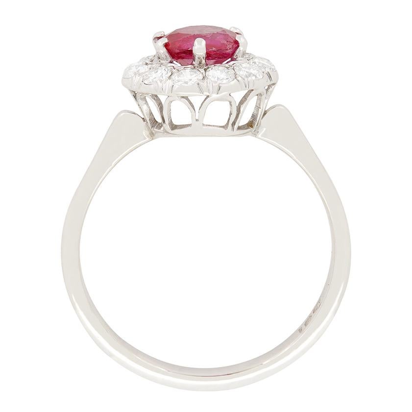 A vivid red Burmese ruby takes centre stage in this Late Deco halo ring. The 1.00 carat old cut ruby is completely natural and unheated making it a highly prized gem. Complementing this central gem is enveloped in a ring of transitional cut