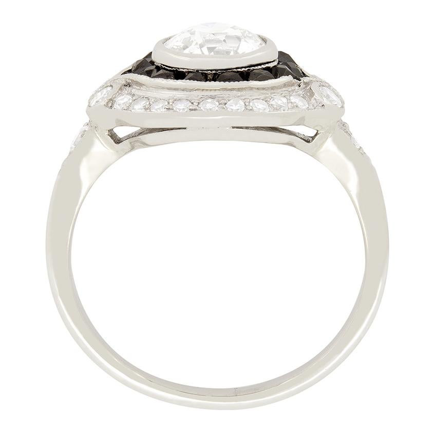 Dating back to the 1940's is this exquisite platinum and diamond ring featuring a halo of prominent French cut black onyx's, totalling to 0.24 carats. Highlighted by the black onyx's is a beautiful 1.01 carat, old cut diamond, graded as G in colour