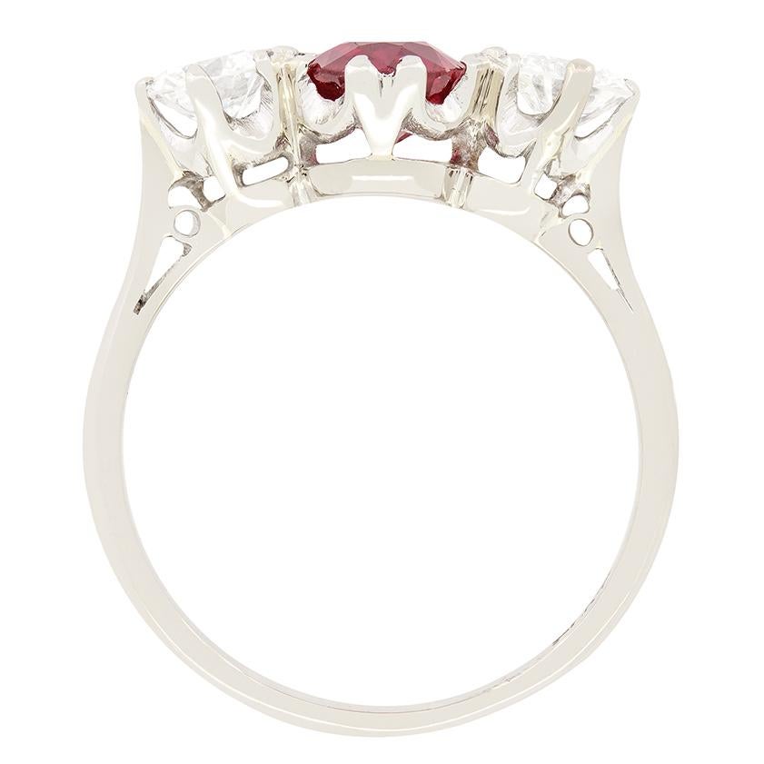 Dating back to the 1940, this stunning trilogy ring features a central ruby flanked by a pair of glittering diamonds. The 1.20 carat central ruby has a beautiful pinky red colour and is oval cut. The round brilliant diamonds set to either side total