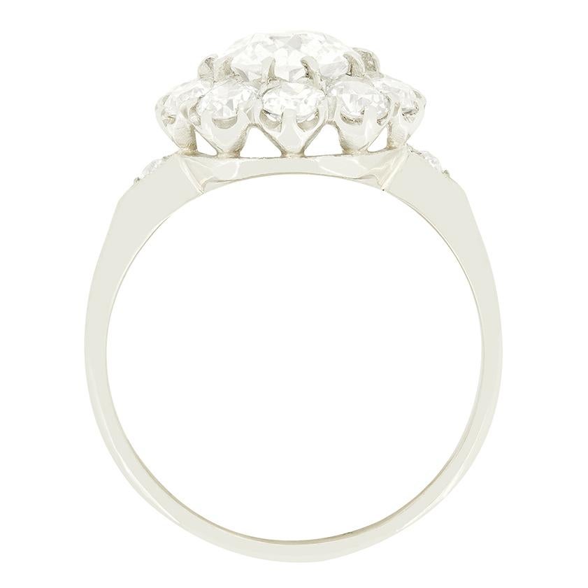 Uno splendido diamante antico è circondato da una scintillante aureola di diamanti in questo anello a grappolo Late Deco. Incastonato in platino lavorato a mano, il diamante centrale pesa 1,25 carati e il gruppo di diamanti ha un peso complessivo di