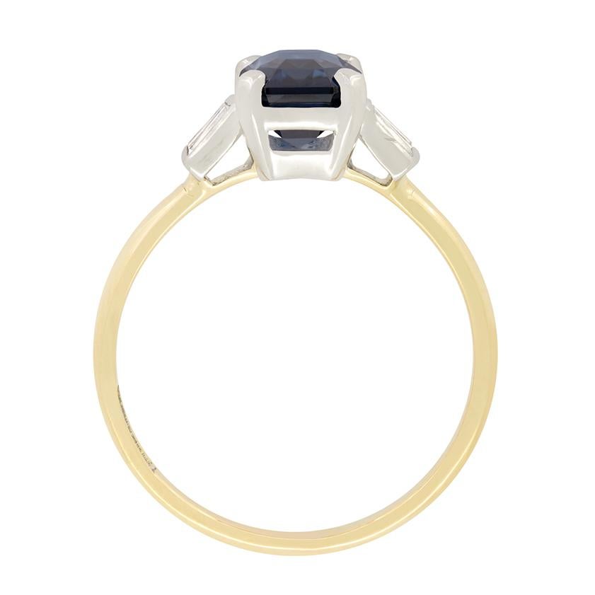 A real eyecatcher, this unique Late Deco solitaire ring holds an impressive 2.80 carat sapphire as it’s centrepiece. An emerald cut stone, this deep blue sapphire is completely natural and unheated. The gem is claw set into a platinum collet with a