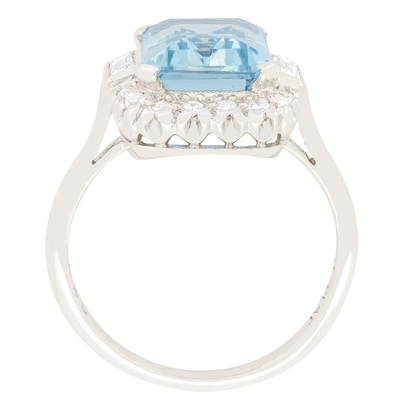 Dating back to the 1940s, this Late Deco aquamarine & diamond cluster ring is a real beauty. The central aqua is a lovely light blue toned gem, it is an emerald cut stone and weighs 3.20 carat. The surrounding diamonds are eight cuts with a pair of