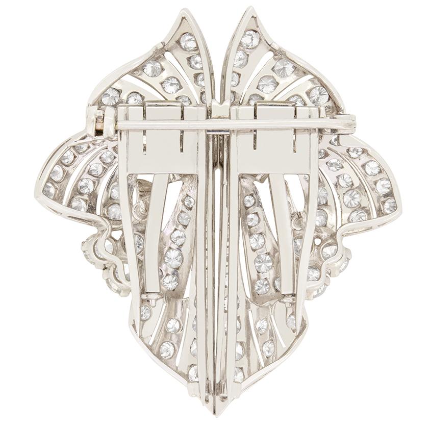 Dating to the Late Deco period, this mesmerising double clip brooch features a wonderfully elaborate design, encrusted with a total of 4.00 carat in diamonds. Across the centre are six rub over set baguette cut diamonds. These are surrounded by A