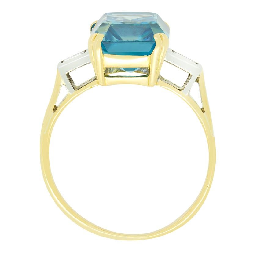 Dating to the 1930s this late deco ring features a vibrant natural blue zircon at its centre. Weighing an impressive 5.00 carat the blue zircon has been cut in an emerald cut enhancing its depth beautifully. On either shoulder a single 0.10 carat