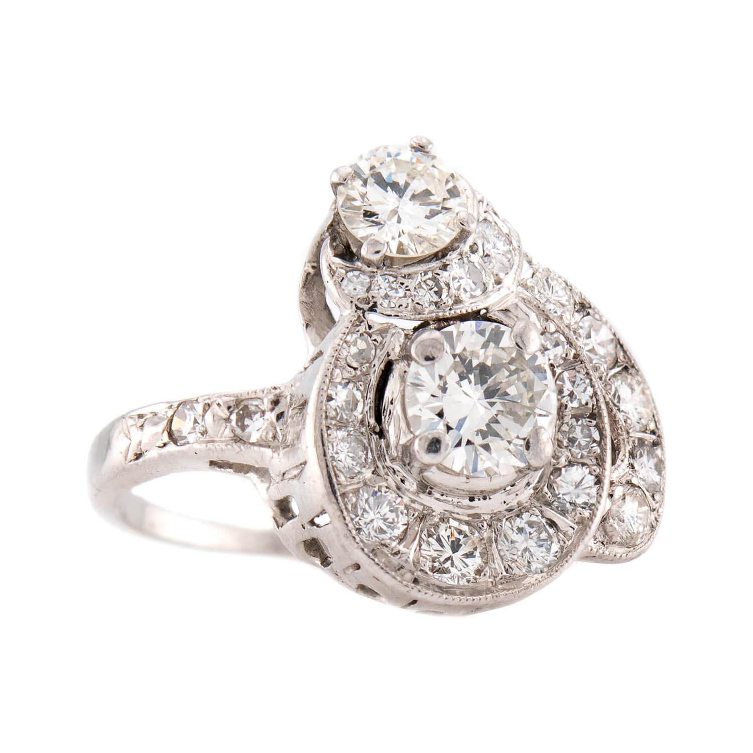 An absolutely lovely diamond cluster ring from the Art Deco (ca1920s) era! Crafted in platinum, this ring takes on a very unique and playful heart-motif design. The entire surface of the 