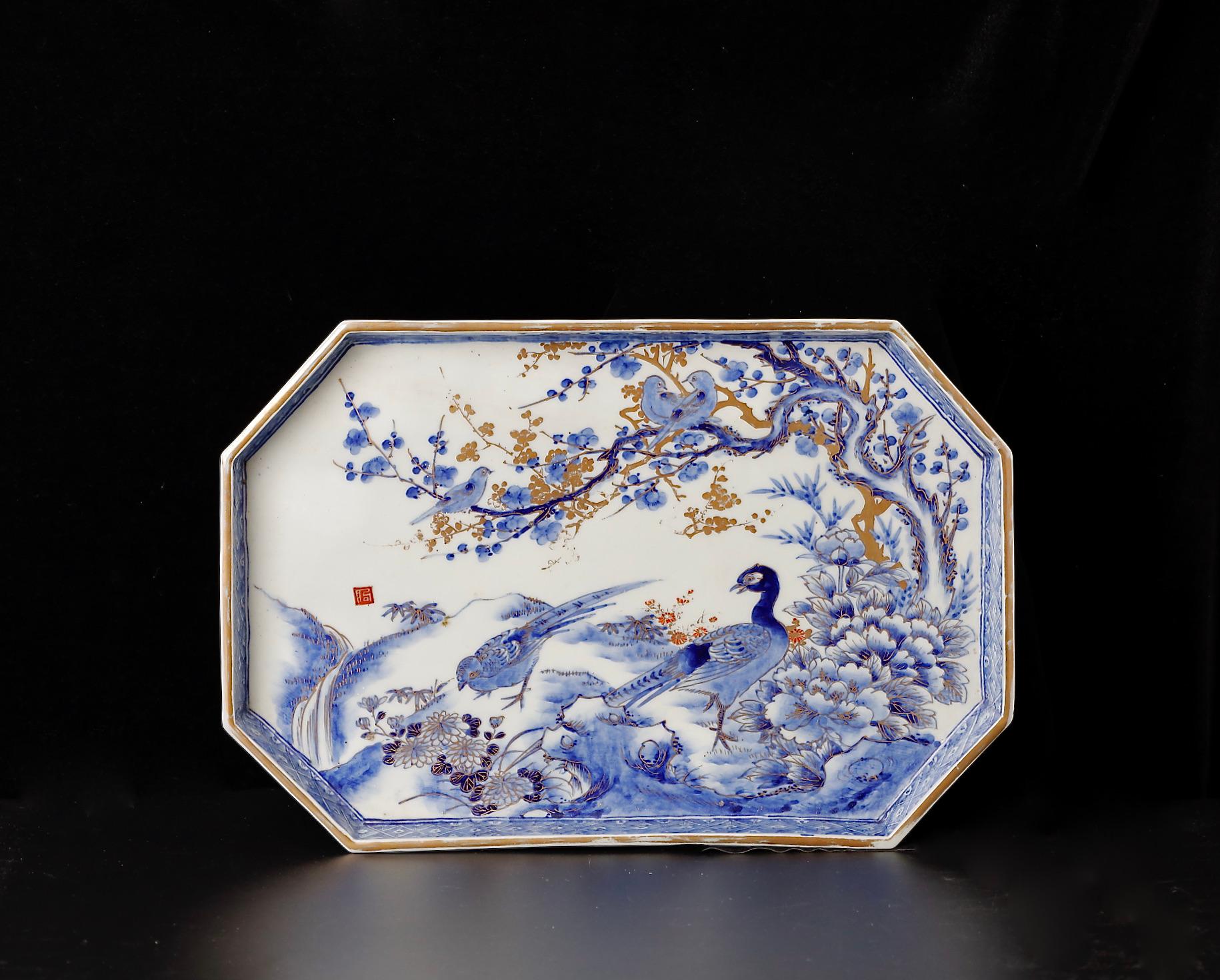 This striking Imari ware plate (SKU: ZD48) is an outstanding representation of late 18th to 19th-century Japanese porcelain artistry, capturing the refined beauty and detailed craftsmanship of the Edo period. The plate features a pair of regal