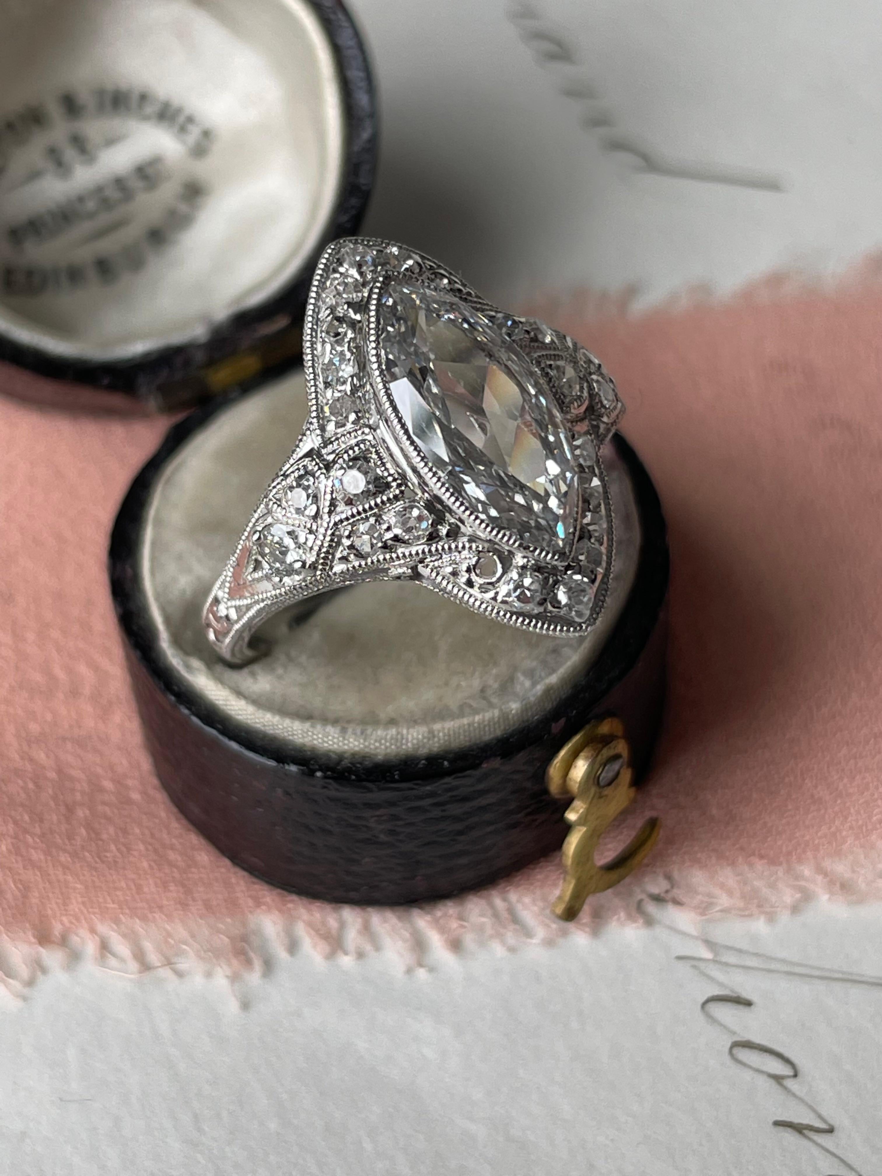 This sweet late Edwardian/early Art Deco ring centers on a sparkling 1.17 carat marquise diamond framed in twinkling single-cut diamonds artfully embellished with delicate piercing and hand-engraved details, finished with crisp millegrain edges.