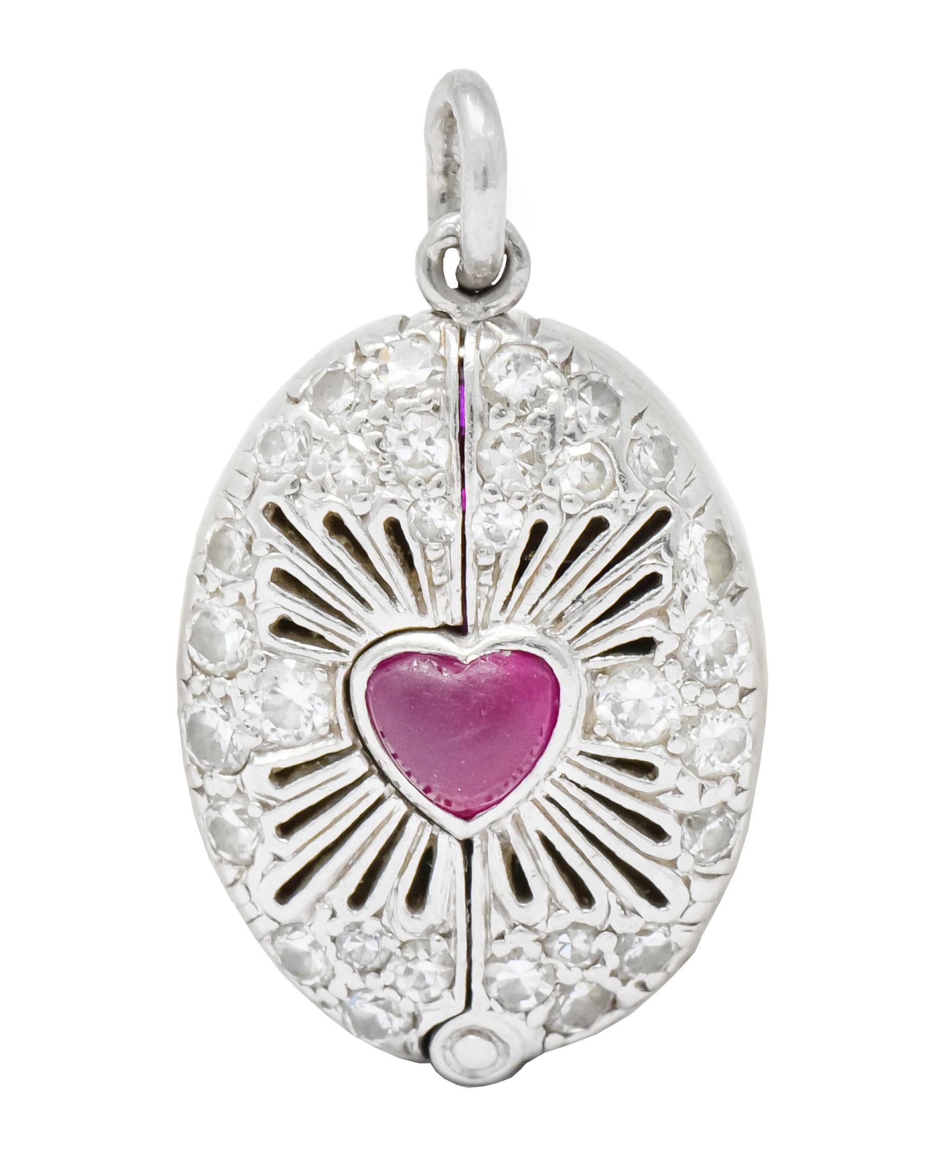 Charm designed as oval centering a ruby cabochon heart surrounded by pierced radiated line motif emulating the Sacred Heart of Jesus

Accented throughout by bead set old European and single cut diamonds weighing approximately

Opens on a hinge to
