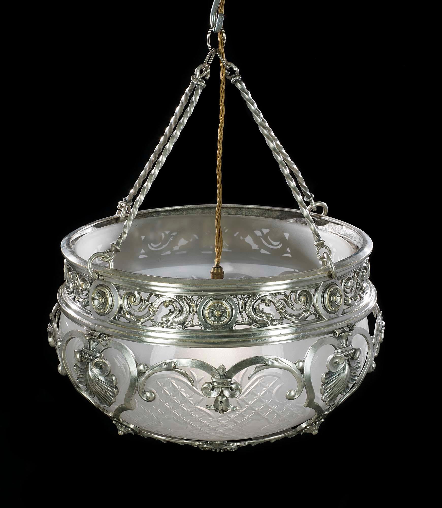 A large and beautifully made late Edwardian silver plated brass ceiling light suspended from four rigid barley twist chains. The cut and frosted glass bowl is held within a highly ornate frame of scrolling tendrils, bellflowers, rosettes and reverse
