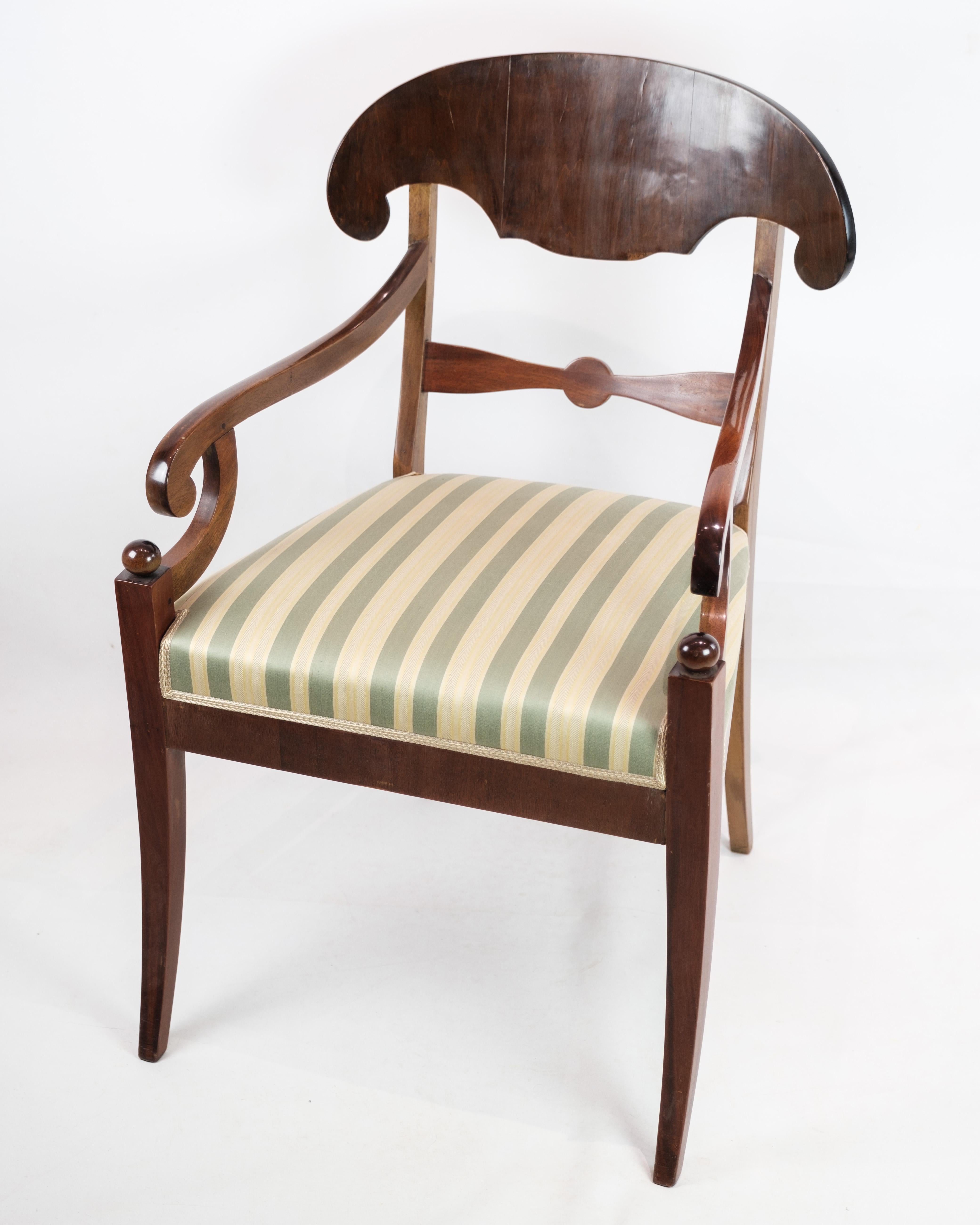 Ce fauteuil de la fin de l'empire, datant d'environ 1840, dégage une élégance intemporelle avec sa structure en acajou et son revêtement en tissu rayé clair. Fabriqué à l'apogée de la période de l'empire, il témoigne d'un savoir-faire exquis et