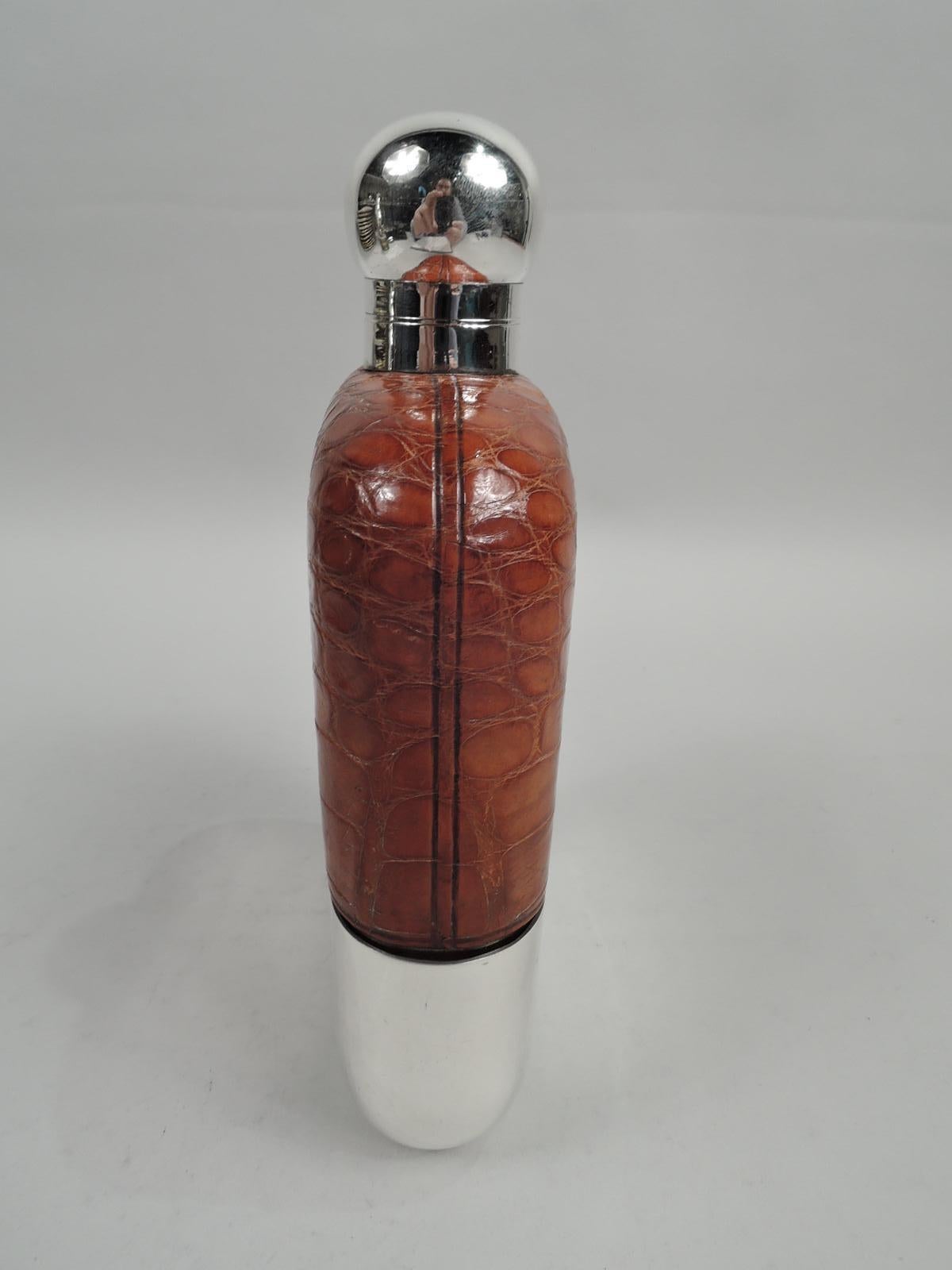 Late Empire safari flask. Made by James Dixon & Sons in Sheffield in 1924. Clear-glass body. Top encased in leather with cutout windows. Bottom has detachable sterling silver cup. Neck sterling silver as is hinged and cork-lined bayonet cover for