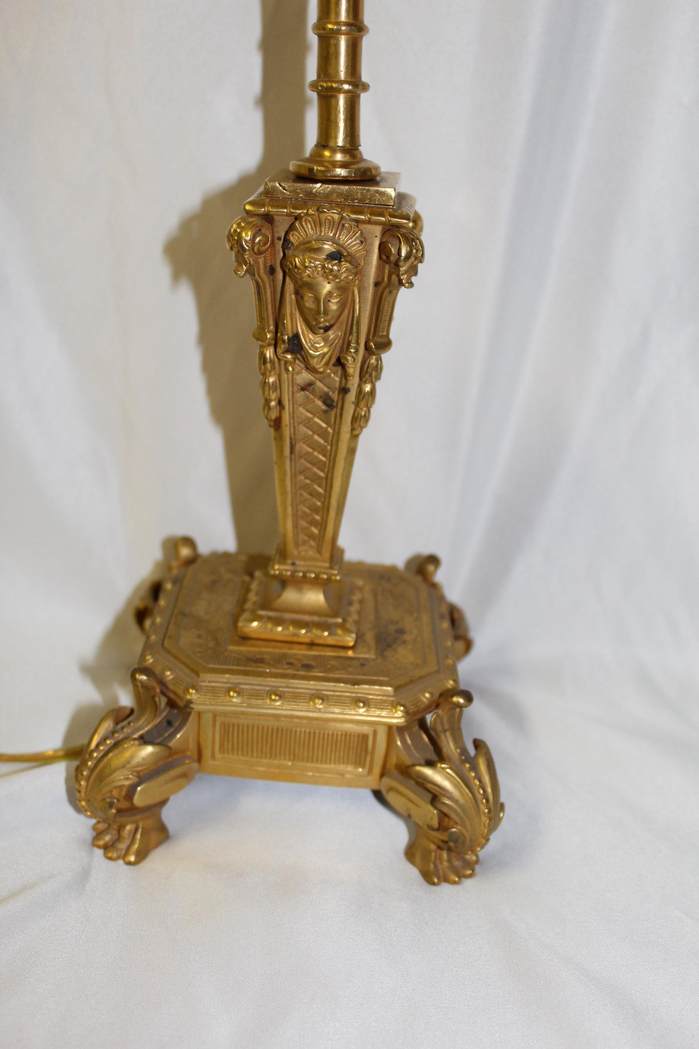 A single late Empire lamp. Has the doré gold finish. With lady face plaques and lion paw feet. Has some spots on the gold, and has been re-wired and new socket. Takes a spring clip shade. No shade 12 