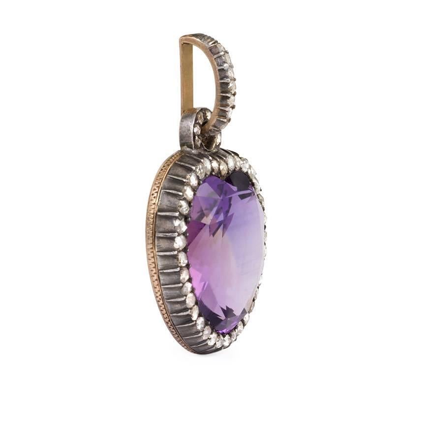 An antique amethyst pendant in the form of a heart with a rose-cut diamond surround and diamond bail, in 15k gold and sterling silver.  England
Amethyst measures approximately 26 x 25mm.