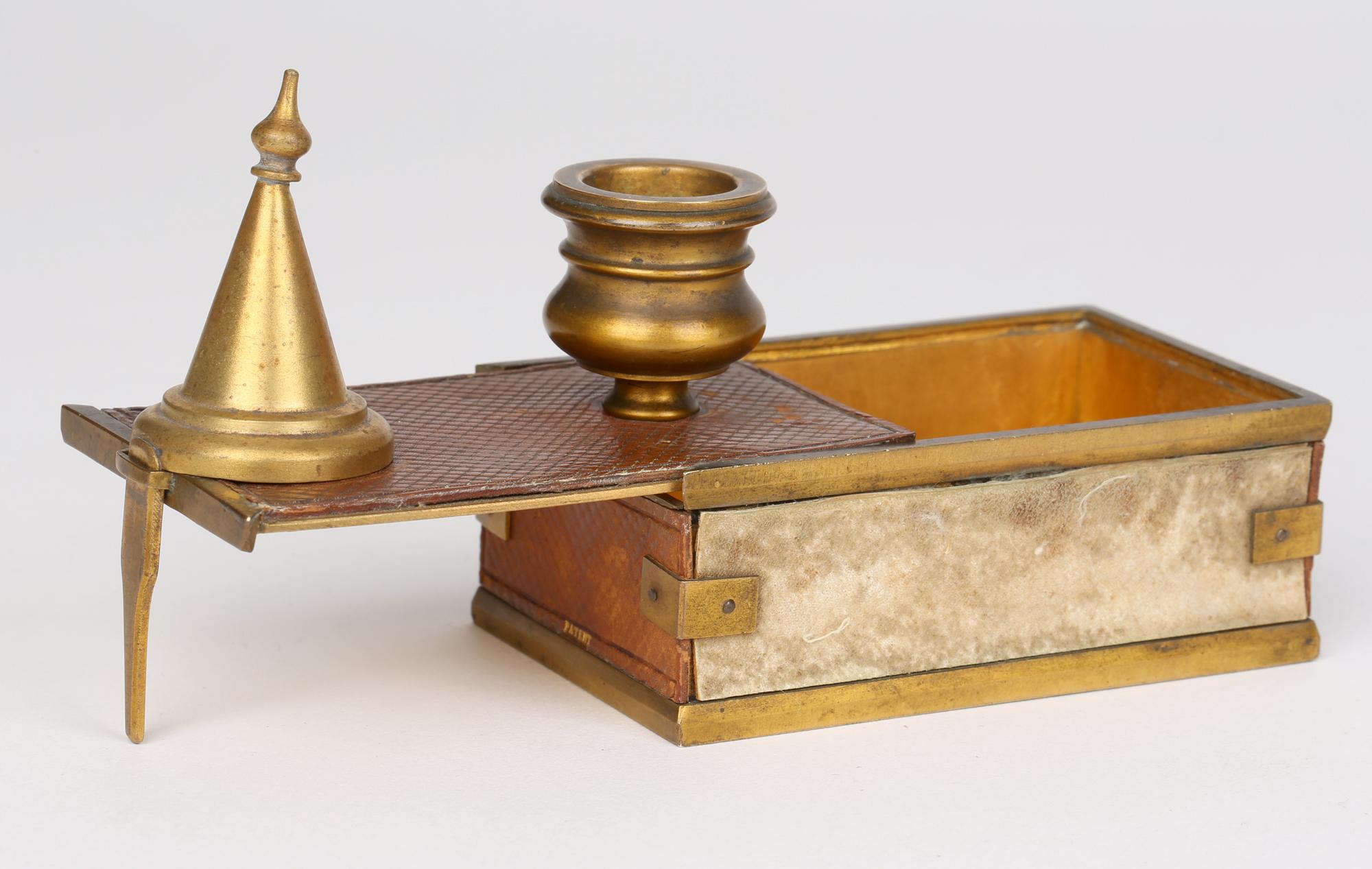 A rare and unusual antique Late Georgian or Regency gilt bronze travelling candle stick with match holder/striker and with a snuffer dating from around 1830. The candlestick is mounted on a gilt bronze rectangular shaped box with a sliding cover and