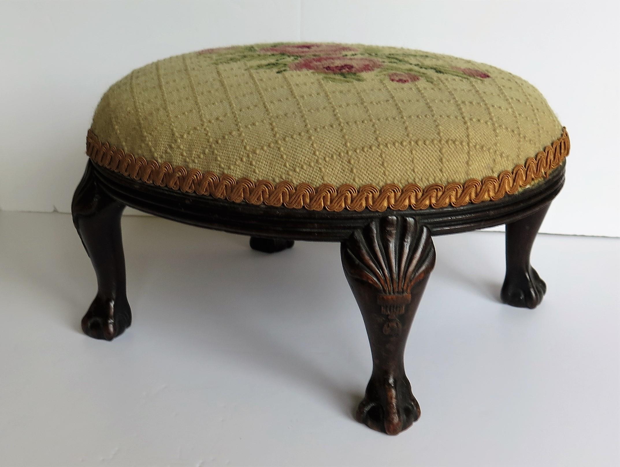 This is a very good quality English walnut oval foot stool on ball and claw feet with a hand embroidered fabric top, from the late Georgian period, circa 1820

The stool is made of walnut with an oval shape on four short legs having crisply hand