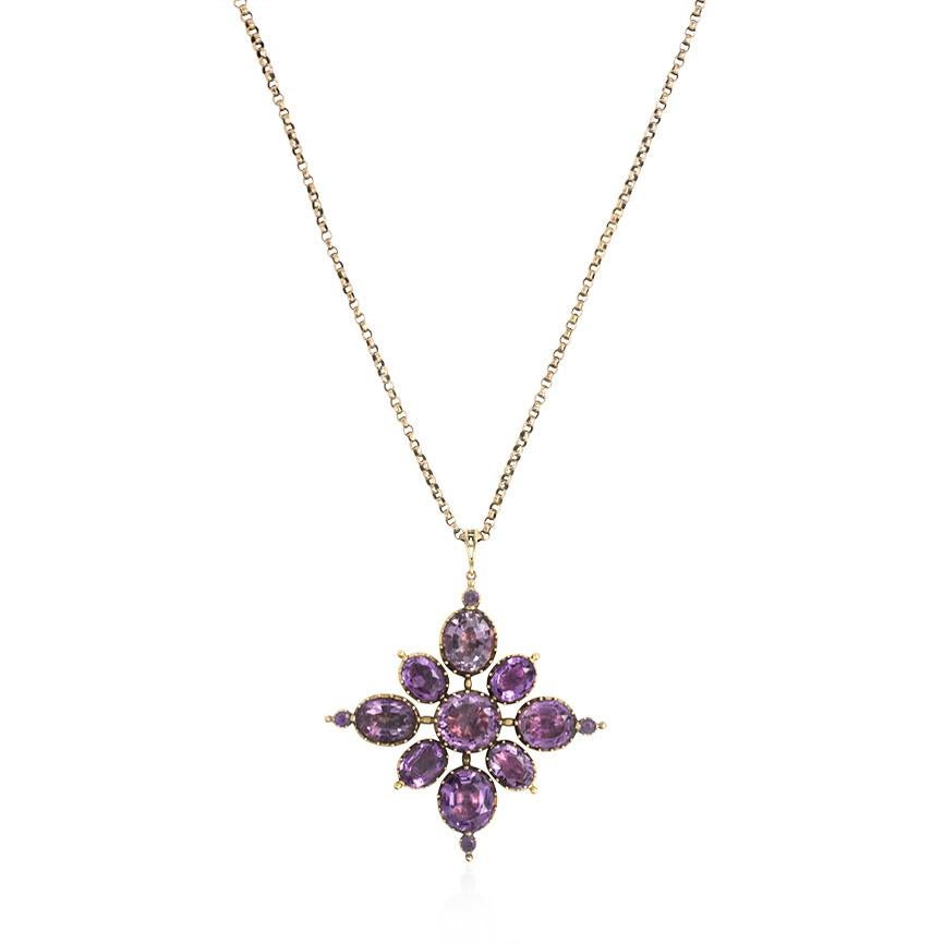 An antique closed and foiled back amethyst pendant of quatrefoil cluster design in 15K gold, on an antique 9K gold chain.  England.

Dimensions: pendant measures approximately 2 5/16