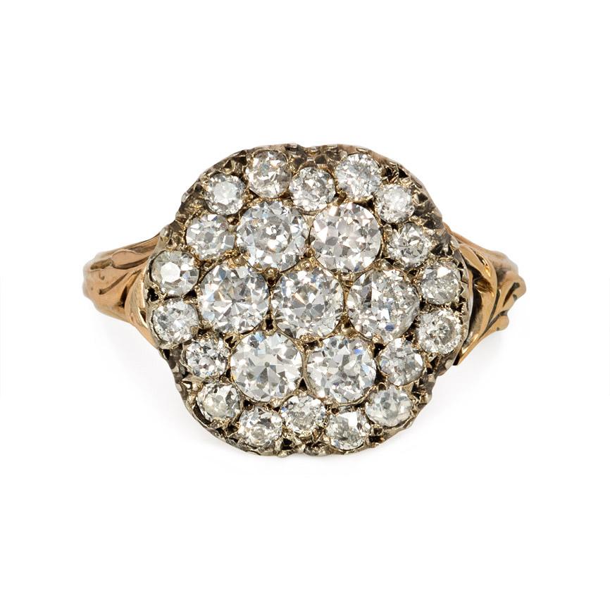 An antique diamond ring designed as a pavé diamond cluster, in 15K gold and sterling silver with pierced shoulders.  England.  Atw. 1.70 ct. old mine cut and single cut diamonds.

Top diameter: approximately 1.5 cm
Current ring size: US 4 (Please