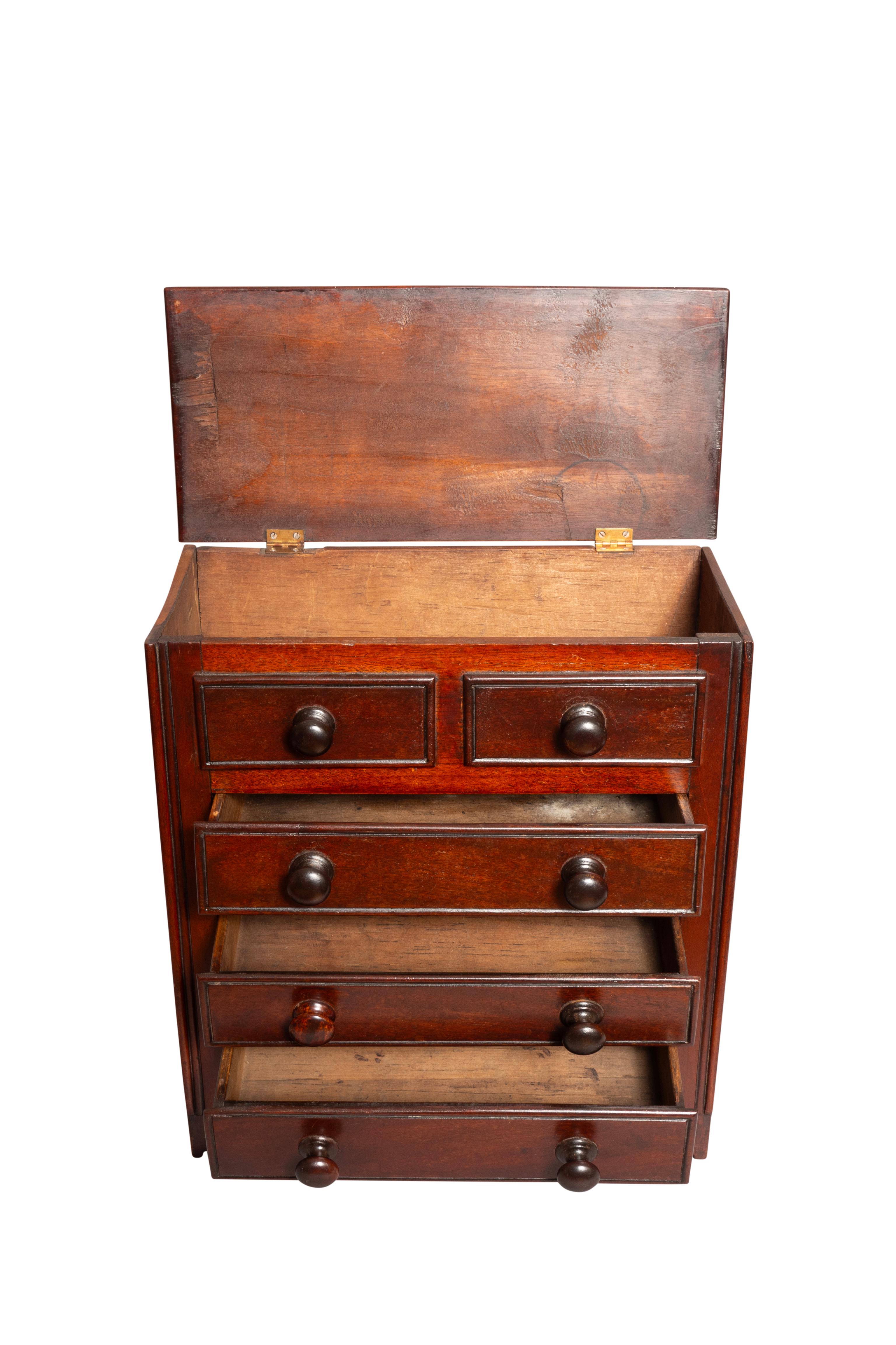 Salesman size chest with lifting top concealing a compartment. Three working drawers below. Bracket feet.