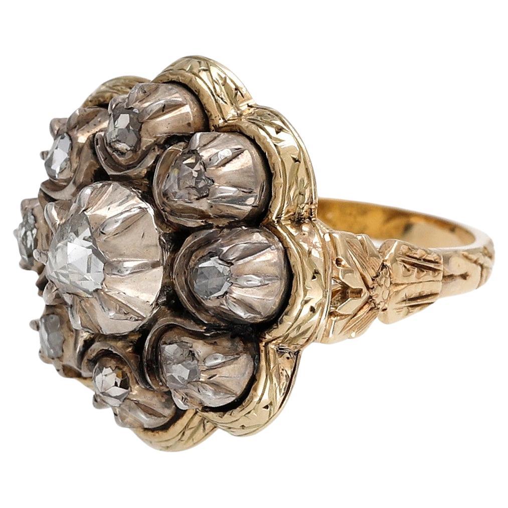 LATE GEORGIAN ROSE CUT DIAMOND CLUSTER RING (Europe Ca. 1830)
Wheel of fire! Eight rose cut diamonds encircle the central diamond. Resembling a star or sun, a mound of silver encases the central diamond with eight pointed rays trailing down the