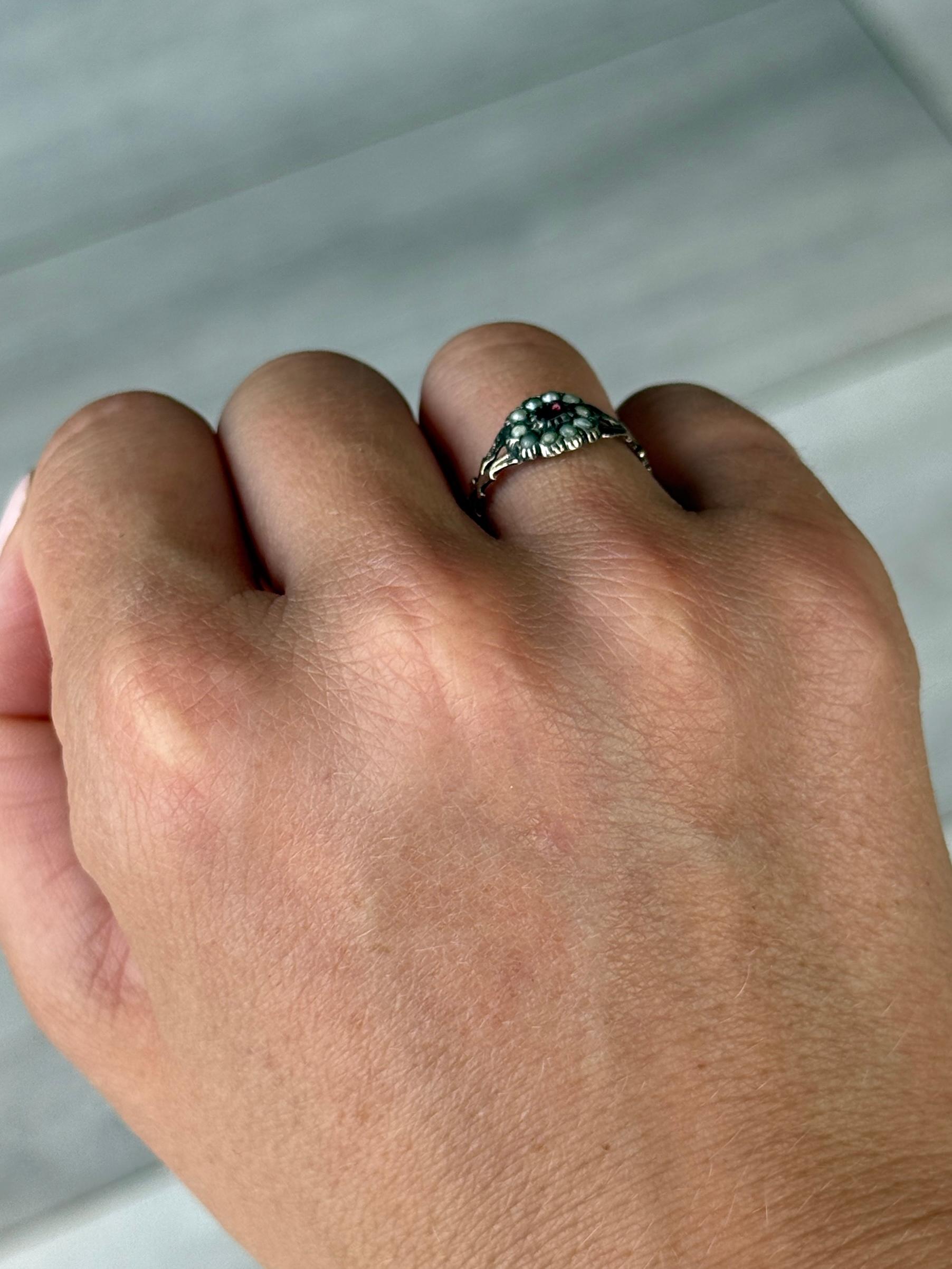 Questo gioiello ha al centro uno splendido rubino, circondato da perle. L'anello è realizzato in oro 9ct.

Misura dell'anello: K 1/2 o 5 1/2 
Dimensioni del cluster: 8x8,5 mm

Peso: 1g