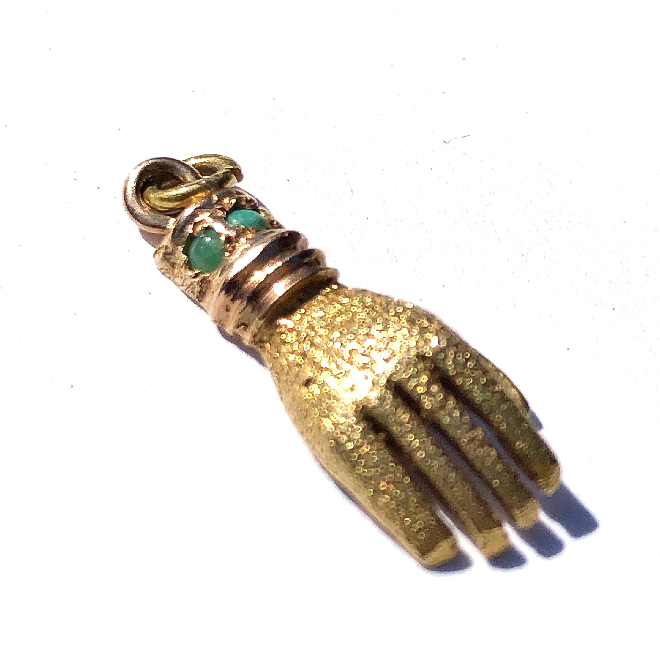 This gorgeous charm is modelled in 15ct gold and around the wrist of this hand are small turquoise stones. The hand itself is textured and the underside and from the wrist, the detail is smooth and glossy.

Widest Side: 2.2cm

Weight: 1.7g