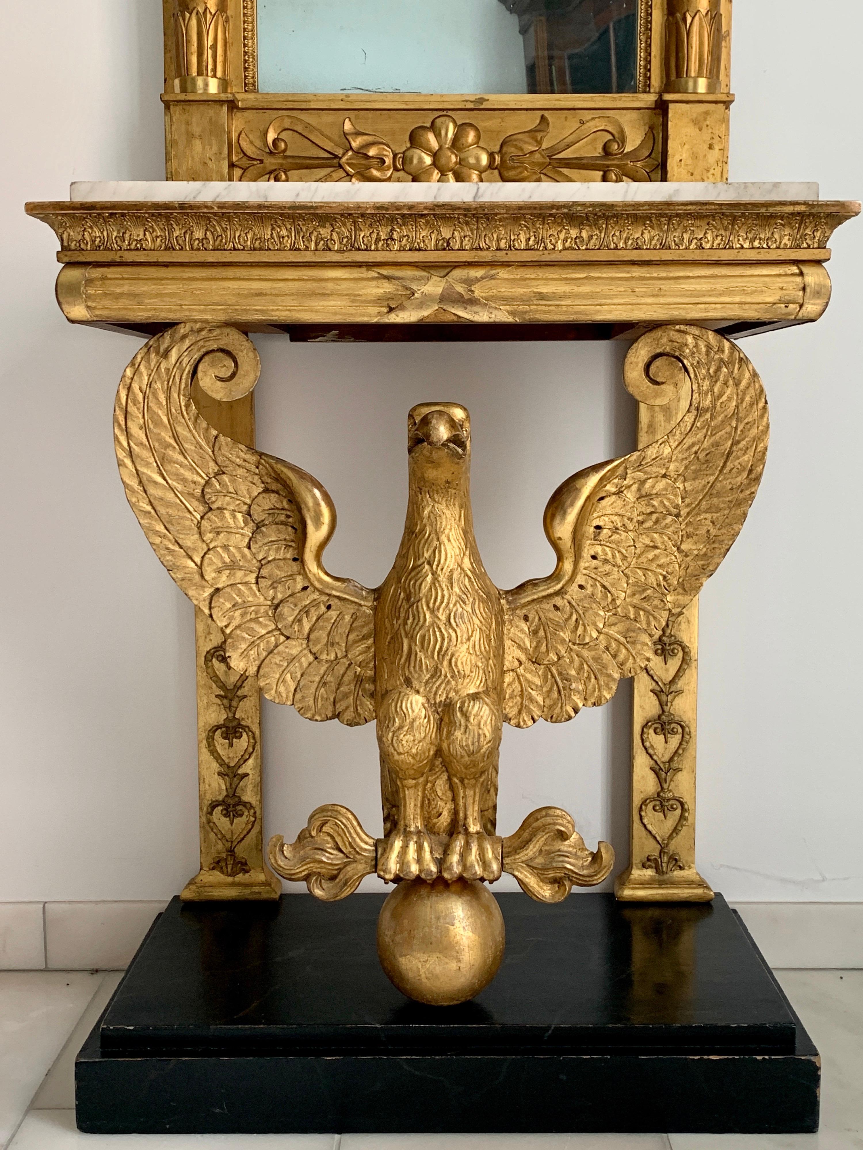 Sehr attraktiver Konsolentisch aus vergoldetem Holz aus dem frühen 19. Jahrhundert mit einem vollständig geschnitzten Adler, der die weiße Marmorplatte trägt. Ein passender Spiegel mit spätem Empire-Dekor. Authentischer Zustand, originaler Marmor,