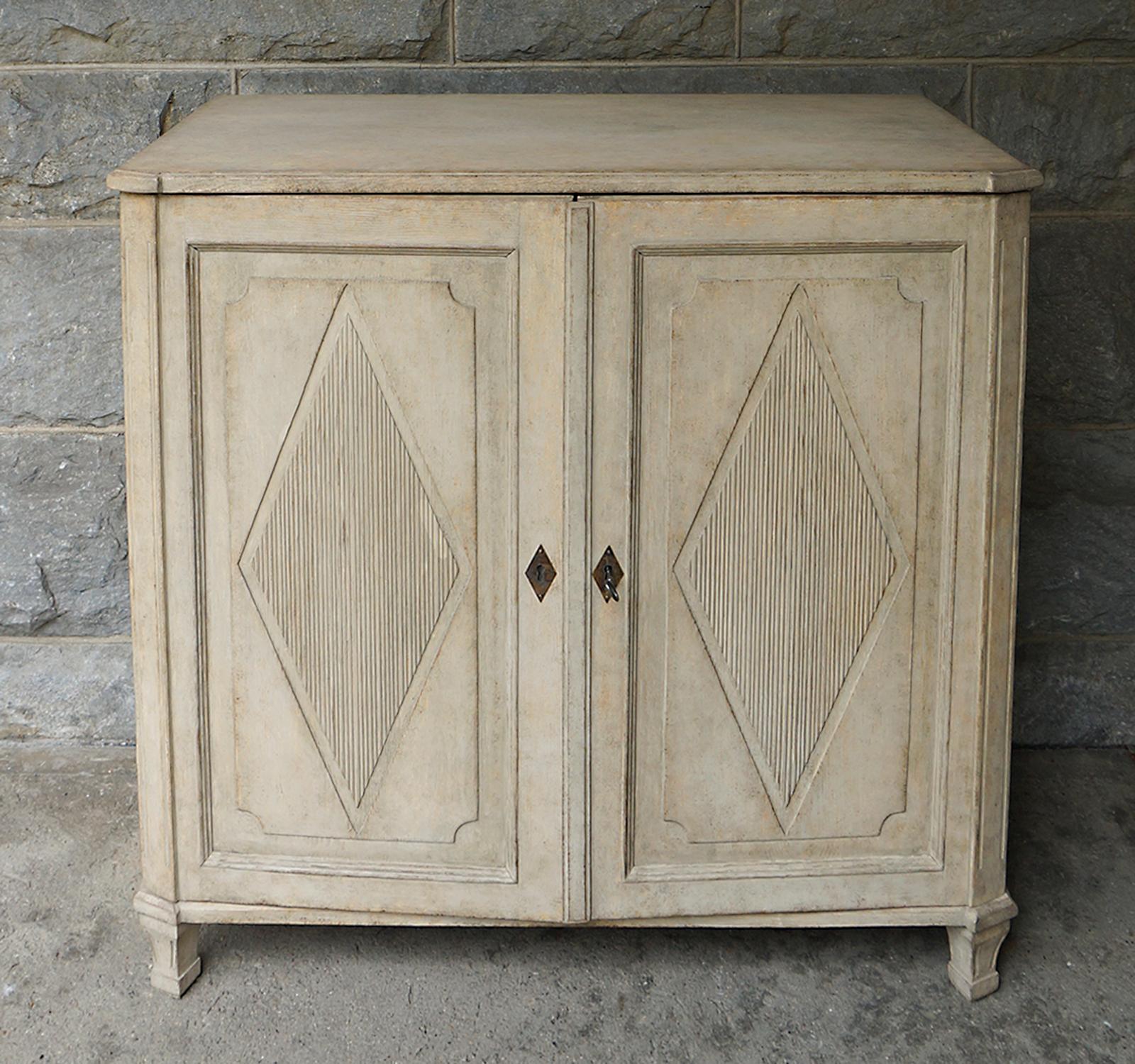 Late Gustavian style sideboard, Sweden circa 1860, with raised, reeded panels on the double doors. Canted corners over tapering square feet. Inside are two drawers over a fixed shelf.