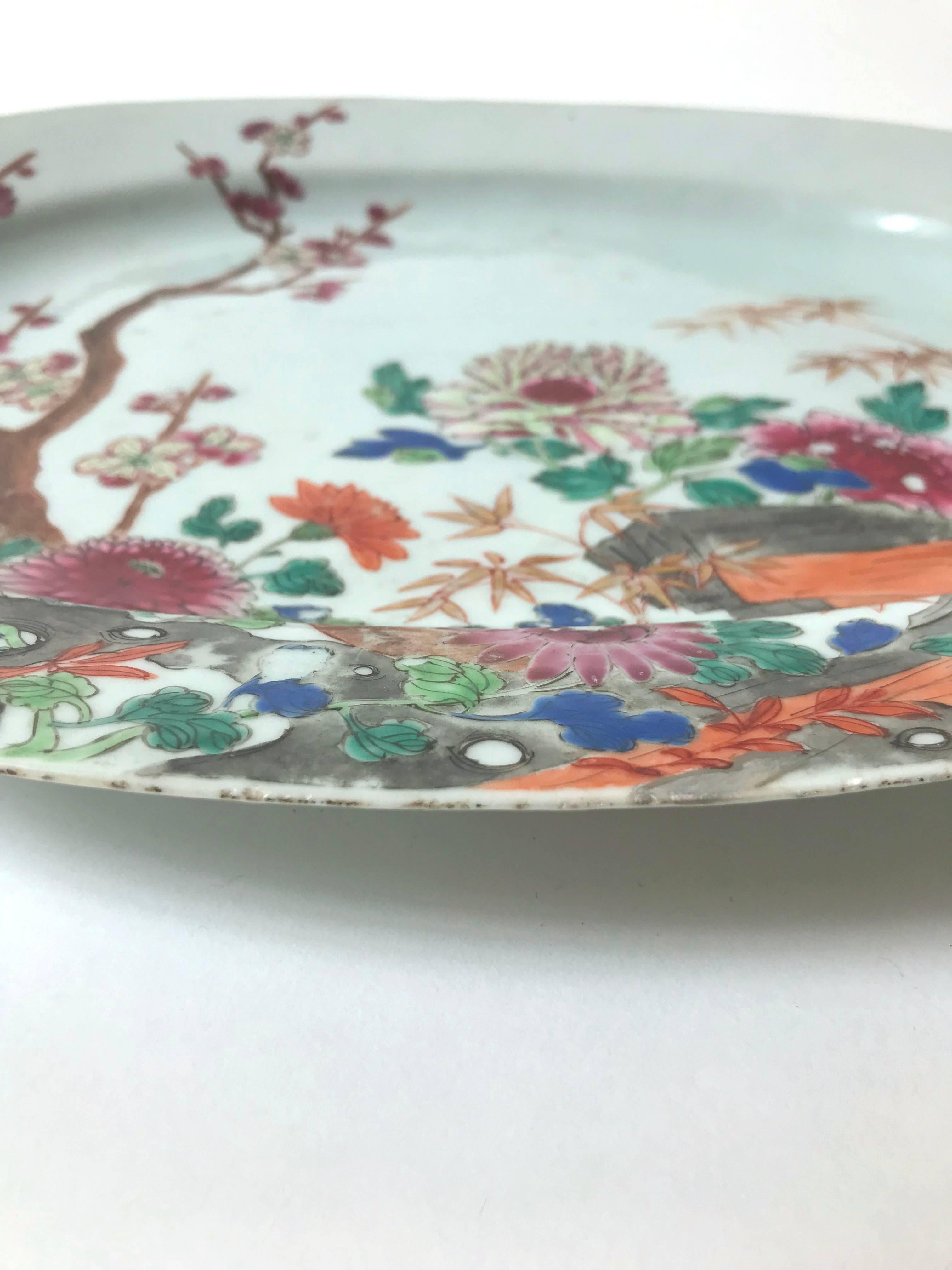 A very fine large Chinese export polychrome porcelain oval platter, dating to the late Kangxi period, circa 1690-1720, decorated in an early palette of famille rose enamels, in a style imitating Japanese kakiemon ko-Imari, depicting a scenic of