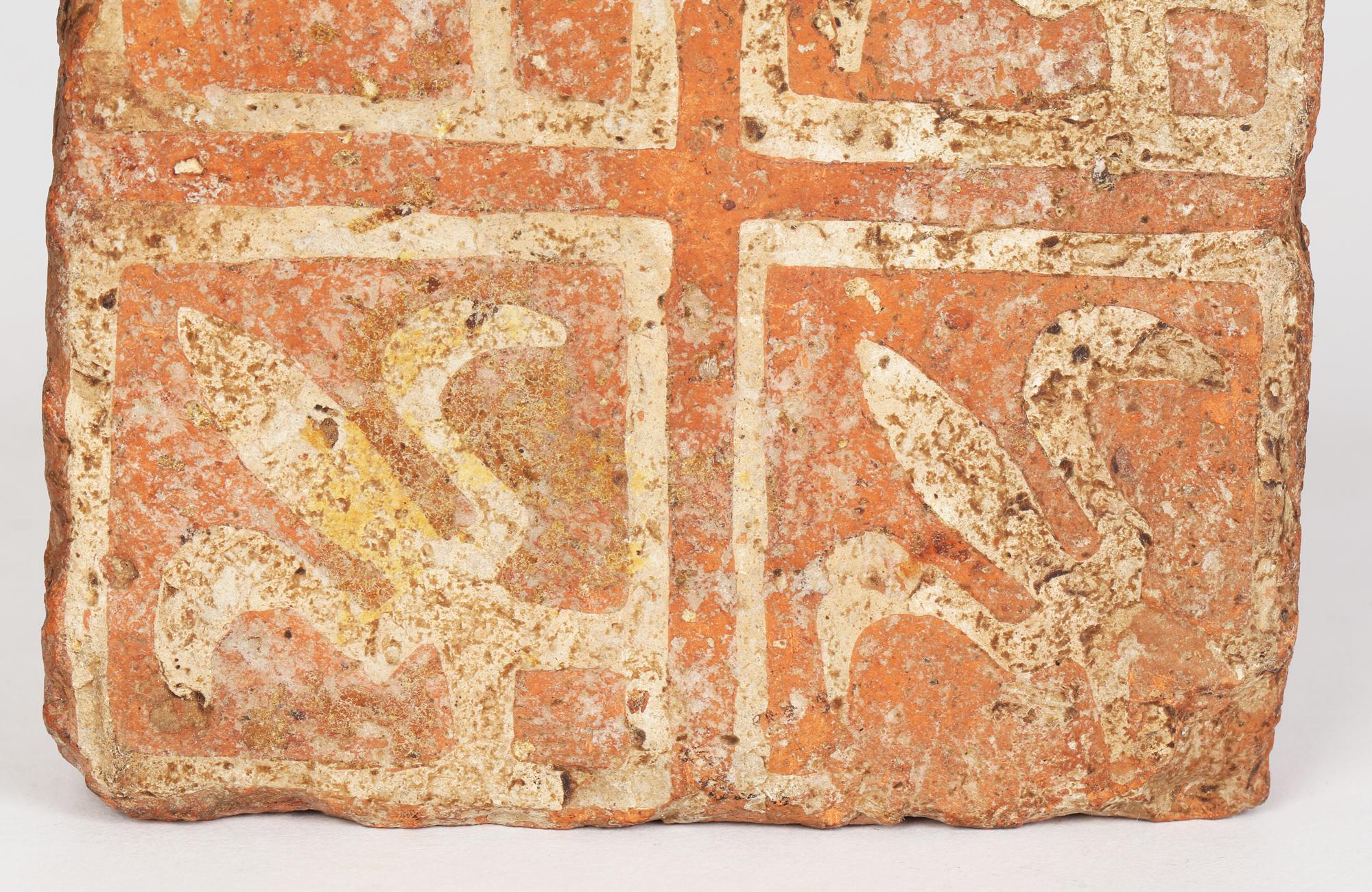 A late medieval encaustic floor tile decorated with a fleur-de-lis design and dating from the 15th century. The tile is thickly made in a terracotta clay inlaid with a cream clay to form the pattern. The tile has four fleur-de-lis designs set within