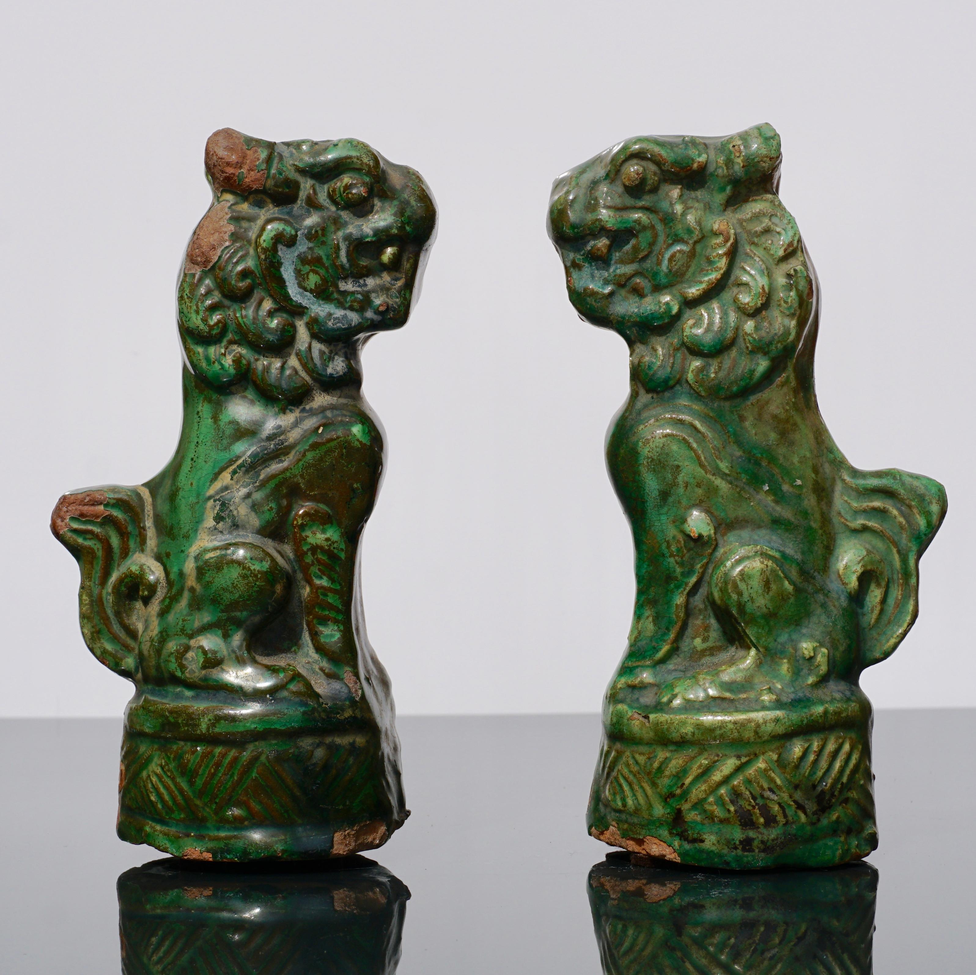 A wonderful pair of late Ming Early Qing Dynasty pottery green glazed Foo dogs or lions from circa 18th century China. A very rare pair as most examples are from roof tiles whereas these are statue figures. These might have been made for tomb