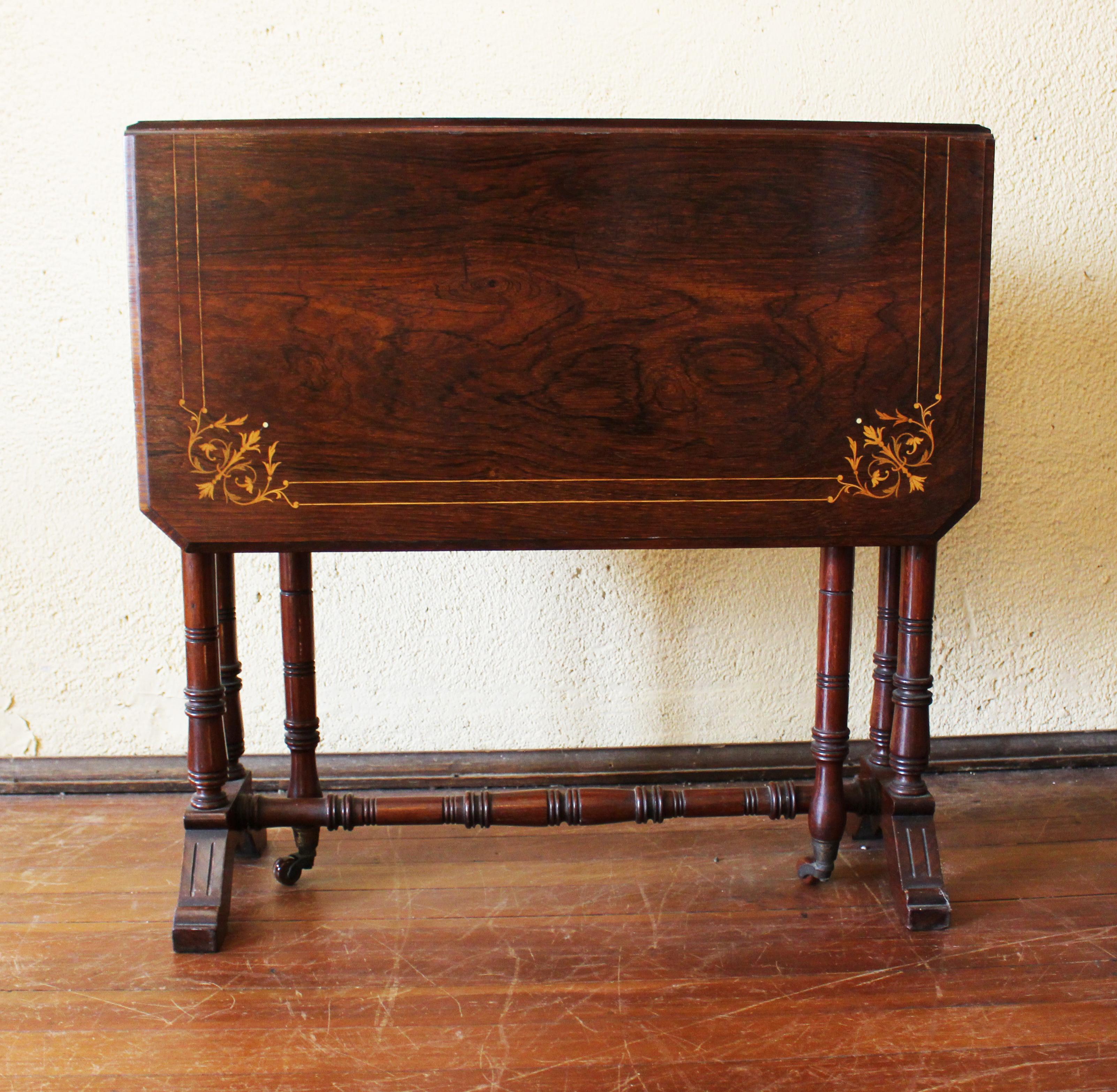 Late 19th century Sutherland table, or drop side table, English. Well figured rosewood with boxwood stringing and naturalistic motif central medallion and corners. Molded edges with canted corners. Well turned and ring carved supports and stretcher.