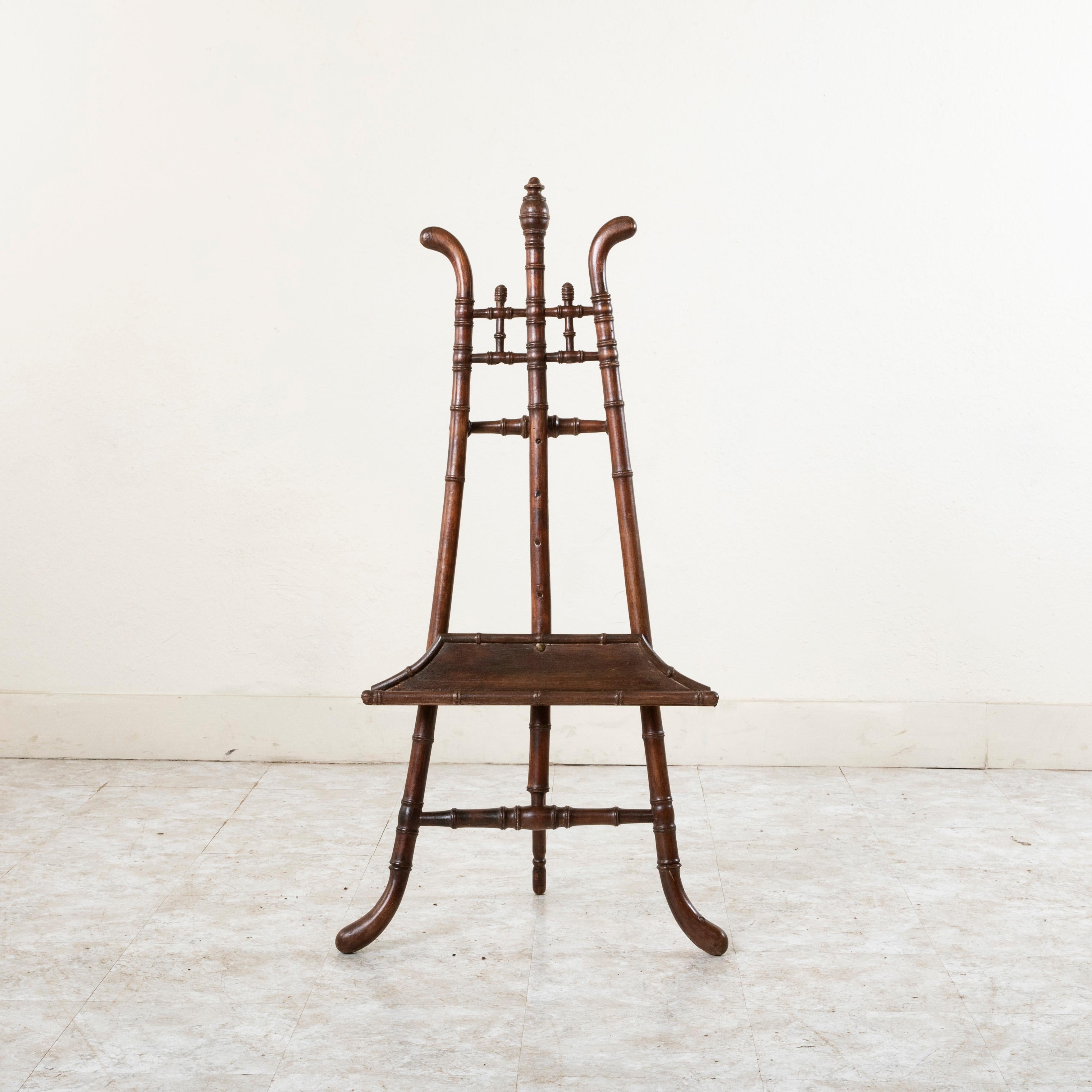 This late nineteenth century French faux bamboo A-frame easel features a 2 inch deep tray which adjusts up and down to different heights by moving the tray to five different heights via a nut and bolt at the back of the tray. The height and pitch of