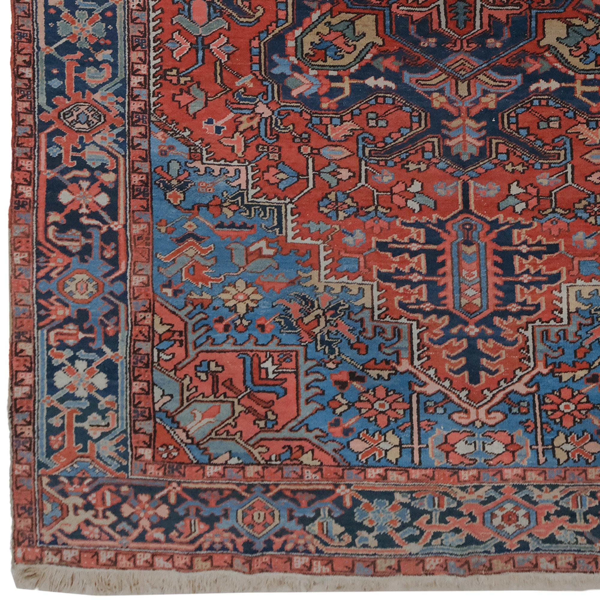 This late 19th century antique Heriz carpet is a unique piece that reflects the rich weaving tradition and aesthetics of the Heriz region in northwestern Iran. Dominated by opulent red, blue and green tones, this carpet offers a striking visual with