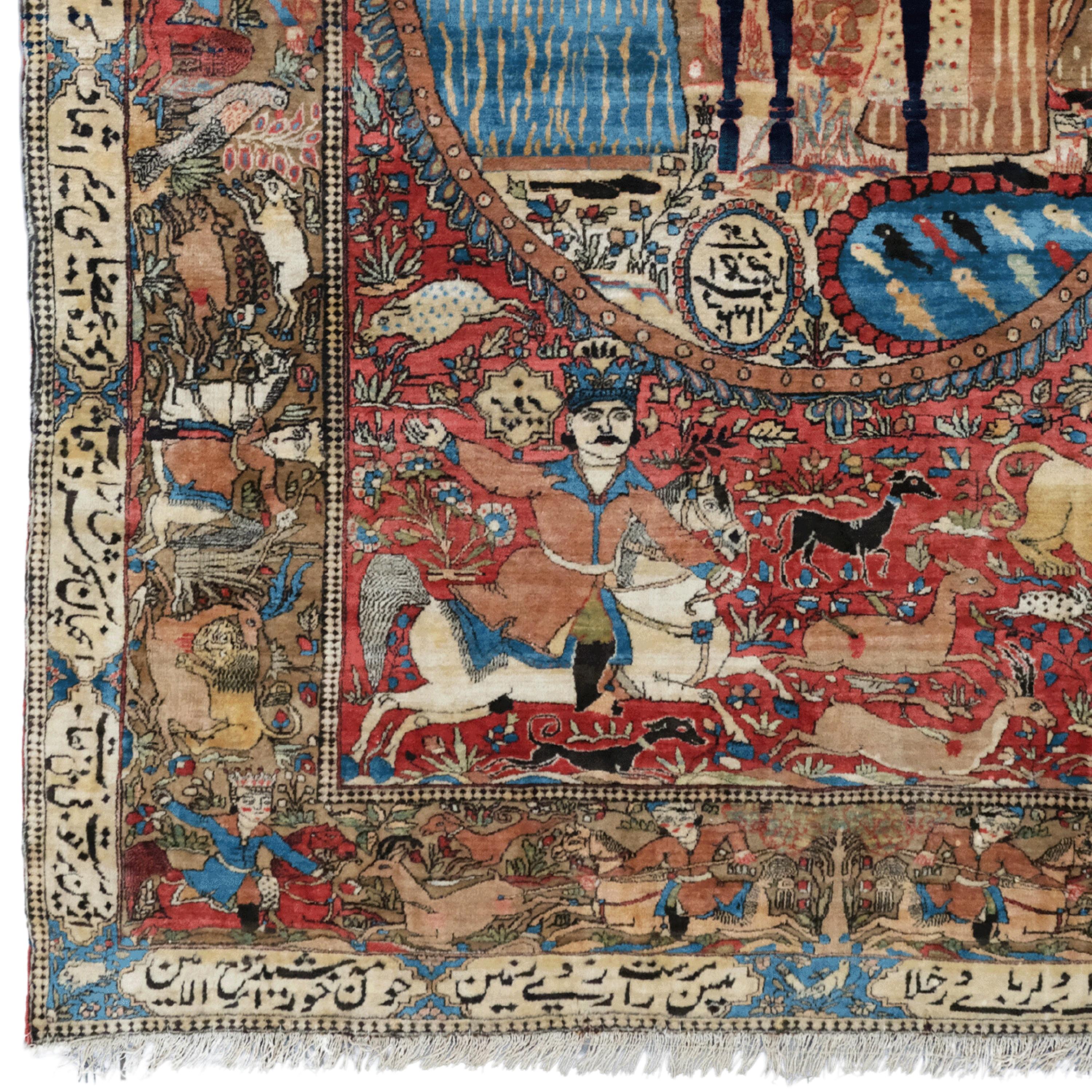 Late of 19th Century Mohteshem Keshan Pictorial Rug 

A red backdrop with a multicolored landscape featuring figured scenes. King Bahram has many animal figures reflecting his hunting. There is an inscription on its borders dedicated to the