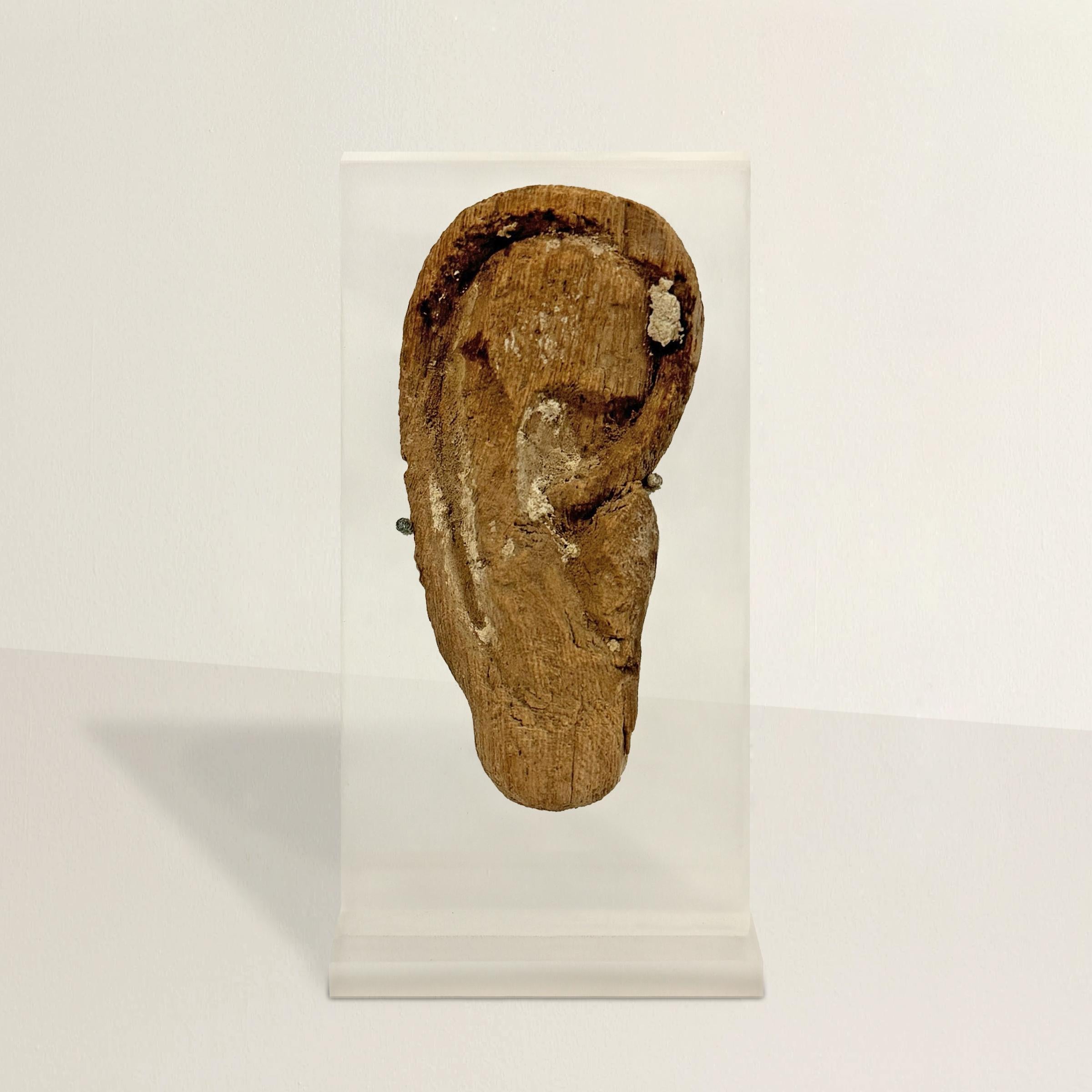 Dieses geschnitzte ägyptische Holzohr aus der späten bis ptolemäischen Periode, das einst zu einer Mumienmaske gehörte, ist ein ergreifendes Zeugnis altägyptischer Bräuche und Glaubensvorstellungen. Sie ist über 2500 Jahre alt und ein