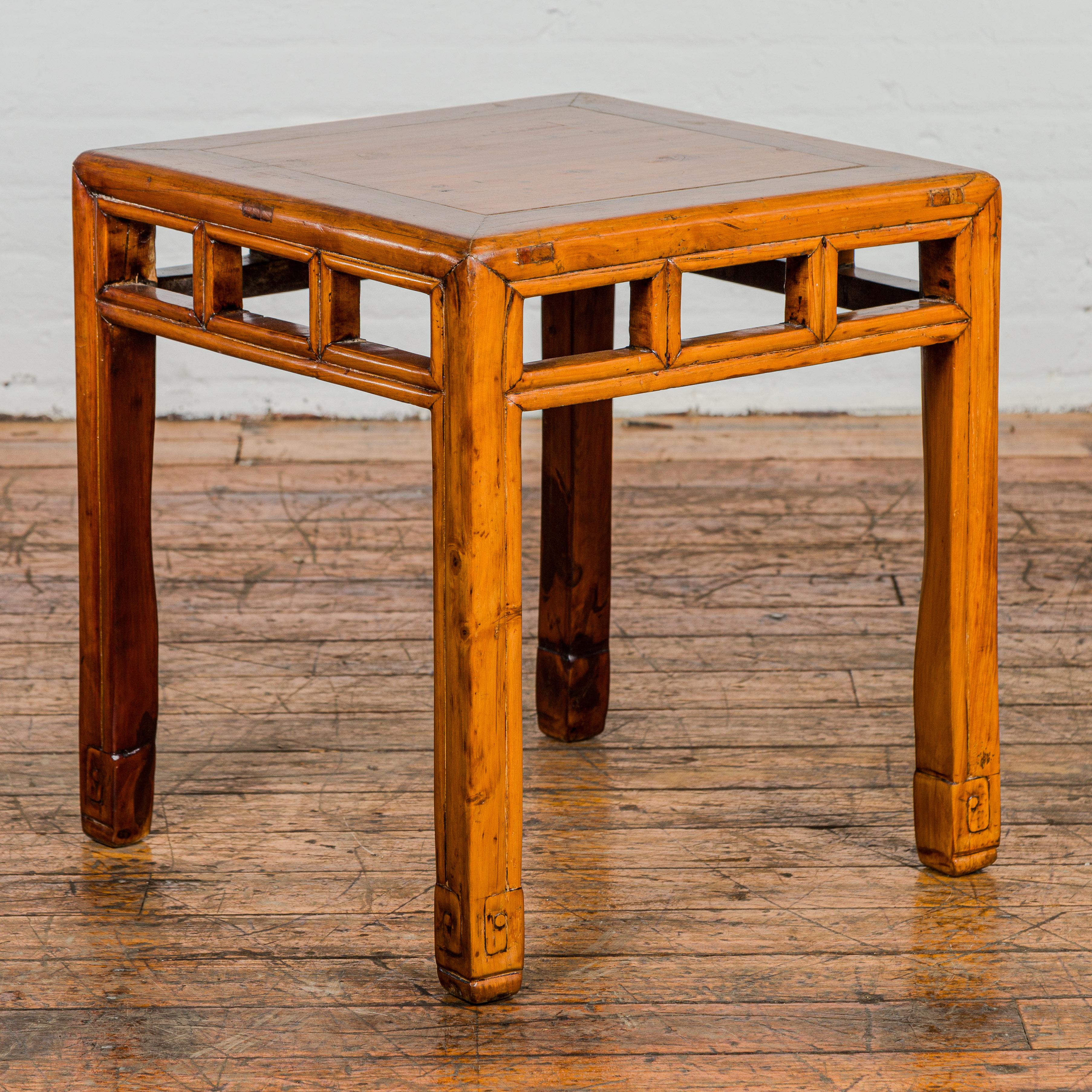 A Late Qing Dynasty period side table with pierced apron adorned with pillar strut motifs and scrolling design on the feet. This Late Qing Dynasty period side table is a true testament to the exquisite craftsmanship of its time. Its intricate design
