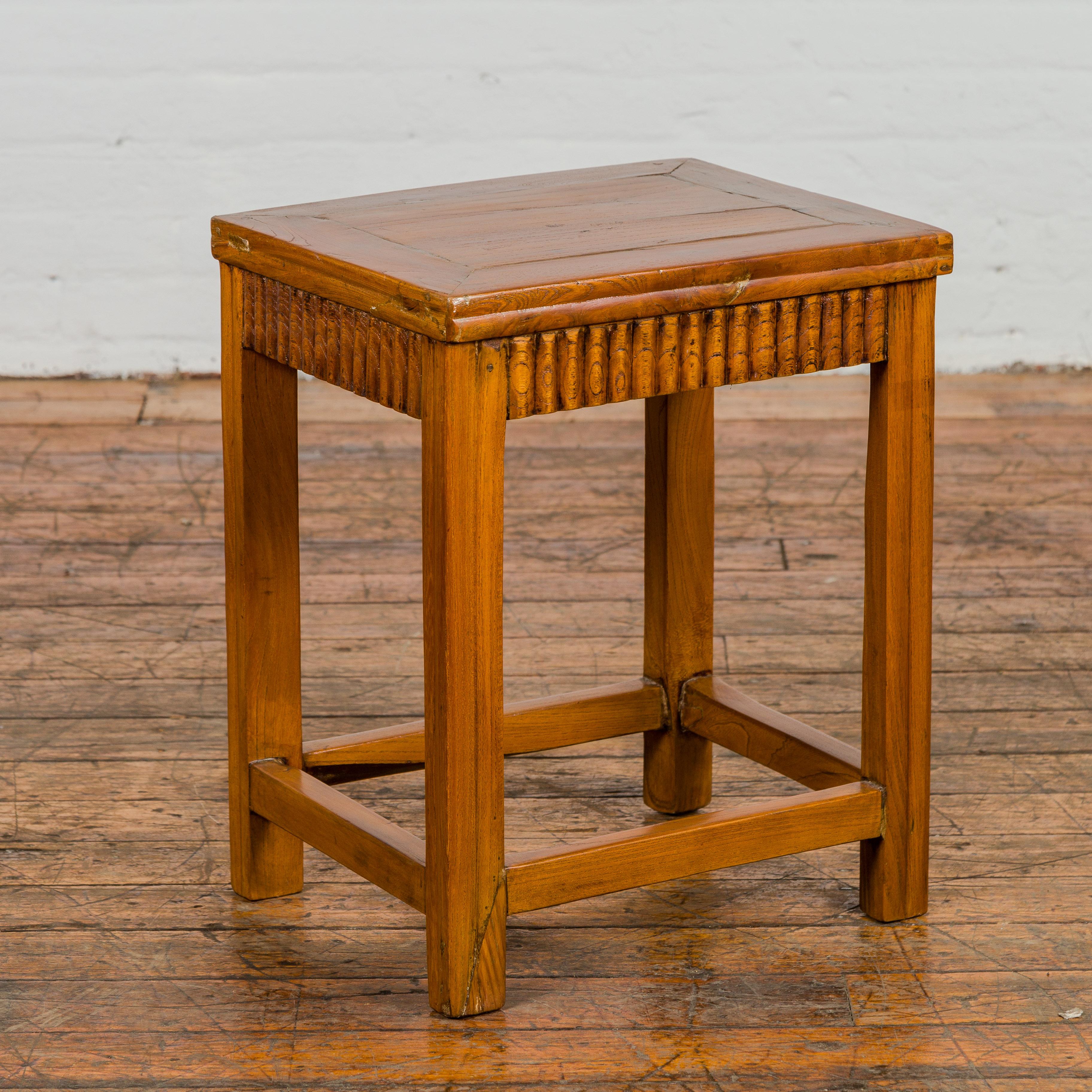 A Chinese late Qing Dynasty period side table with carved reeded apron on all sides, straight legs and side stretchers. This Chinese late Qing Dynasty period side table is distinguished by its carved reeded apron, which gracefully adorns all sides,