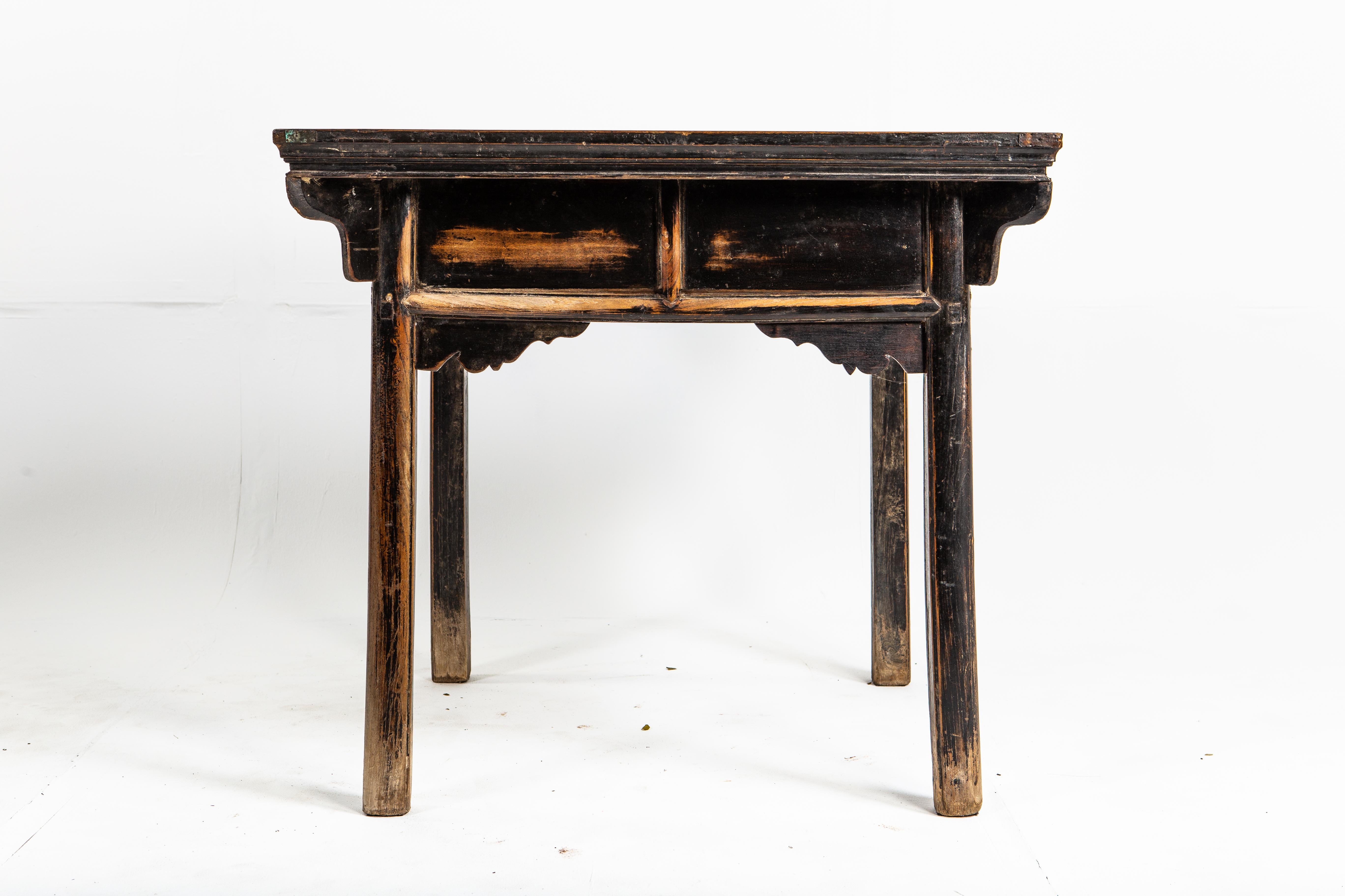 This late-Qing dynasty side table is made of elm. The piece has a hearty feel; it features its original patina, worn from age and use. The table features two drawers.
