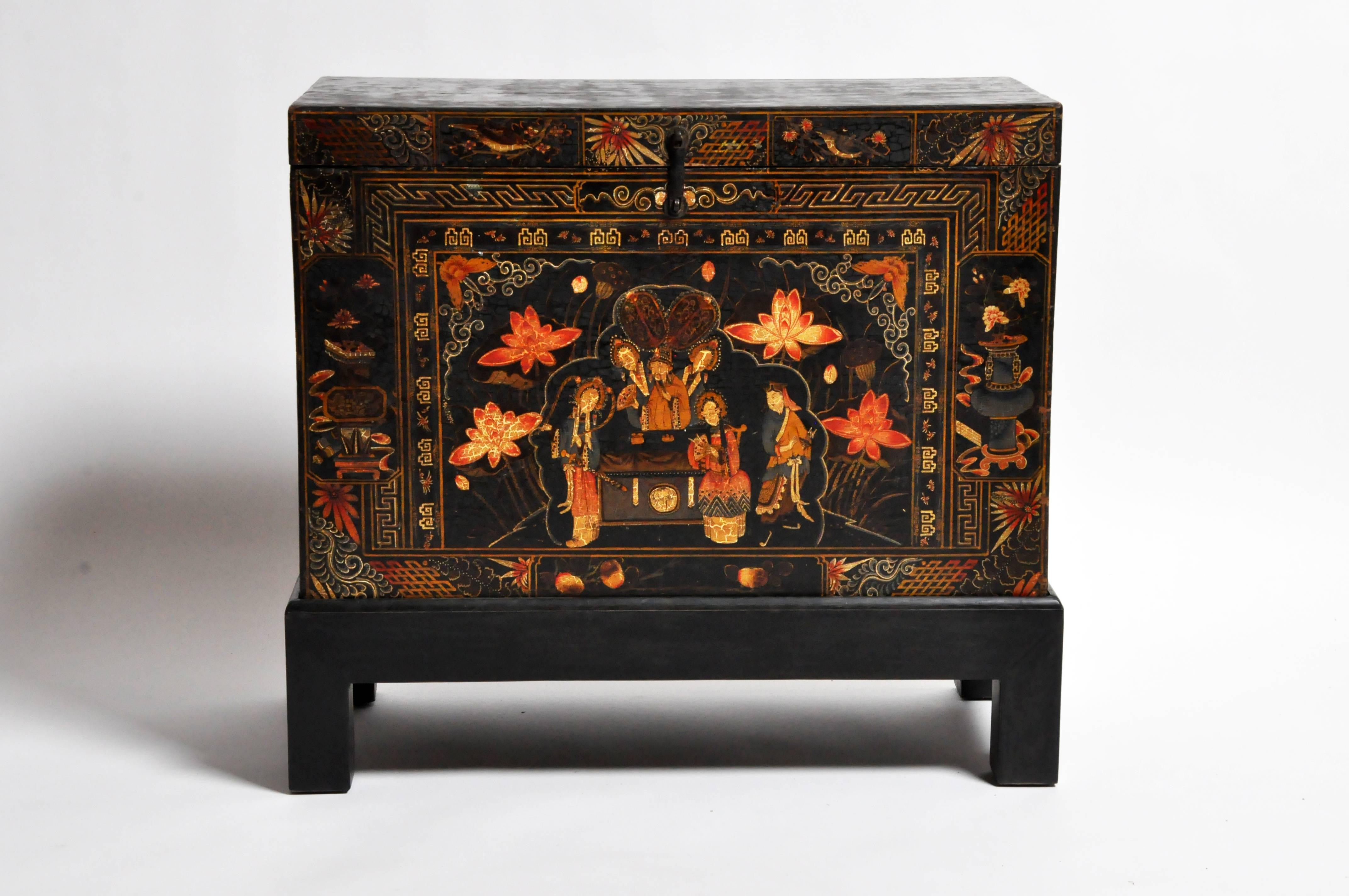 A late Qing dynasty chest from Shanxi China made from teak wood with paint. The piece has been elevated with a black wooden base and has a beautiful aged patina.