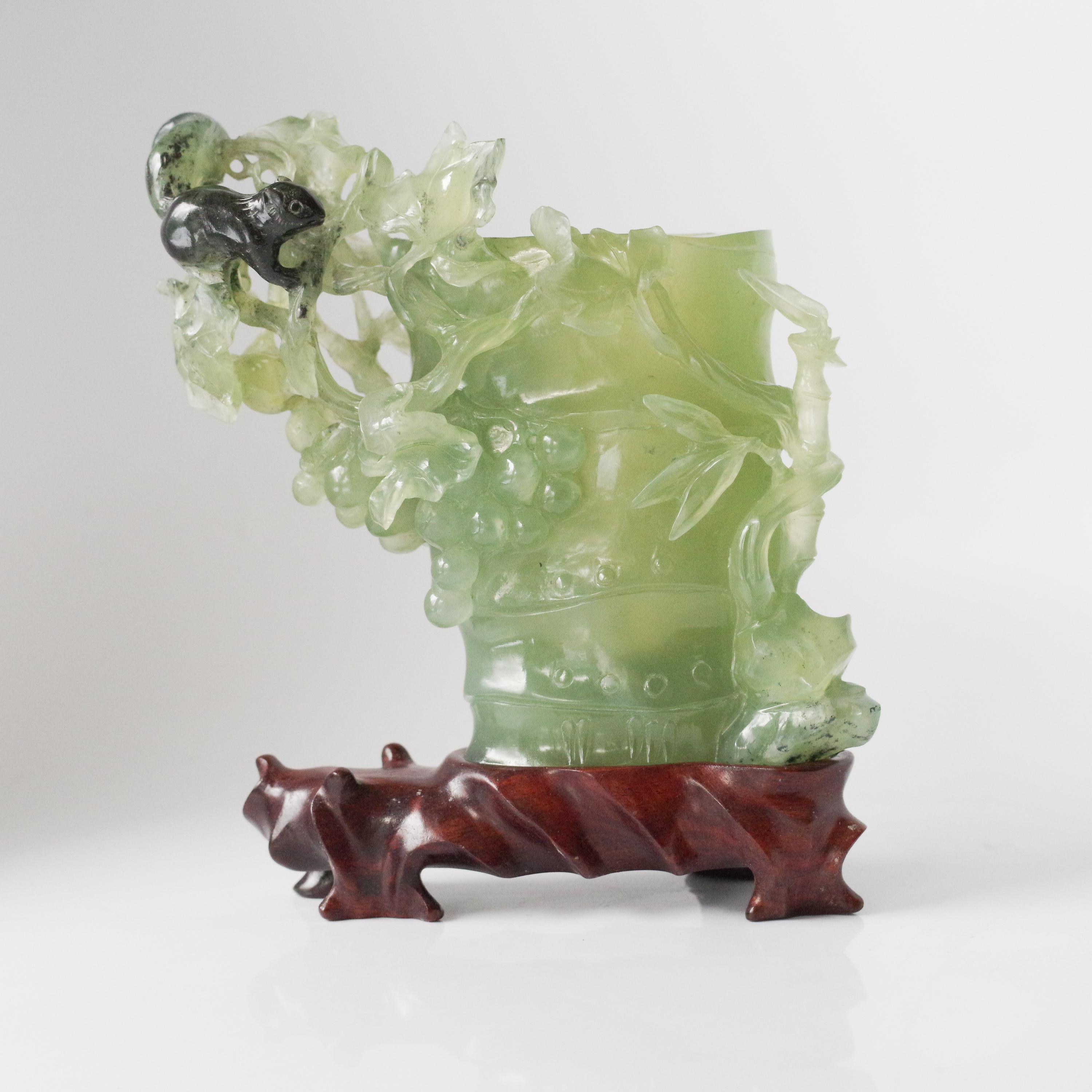 Esta escultura de jade nefrita, exquisitamente tallada, data del periodo comprendido entre finales de la dinastía Qing y principios de la República, aproximadamente entre 1880 y 1920, y es un ejemplo bellamente realizado de las tallas de escritorio