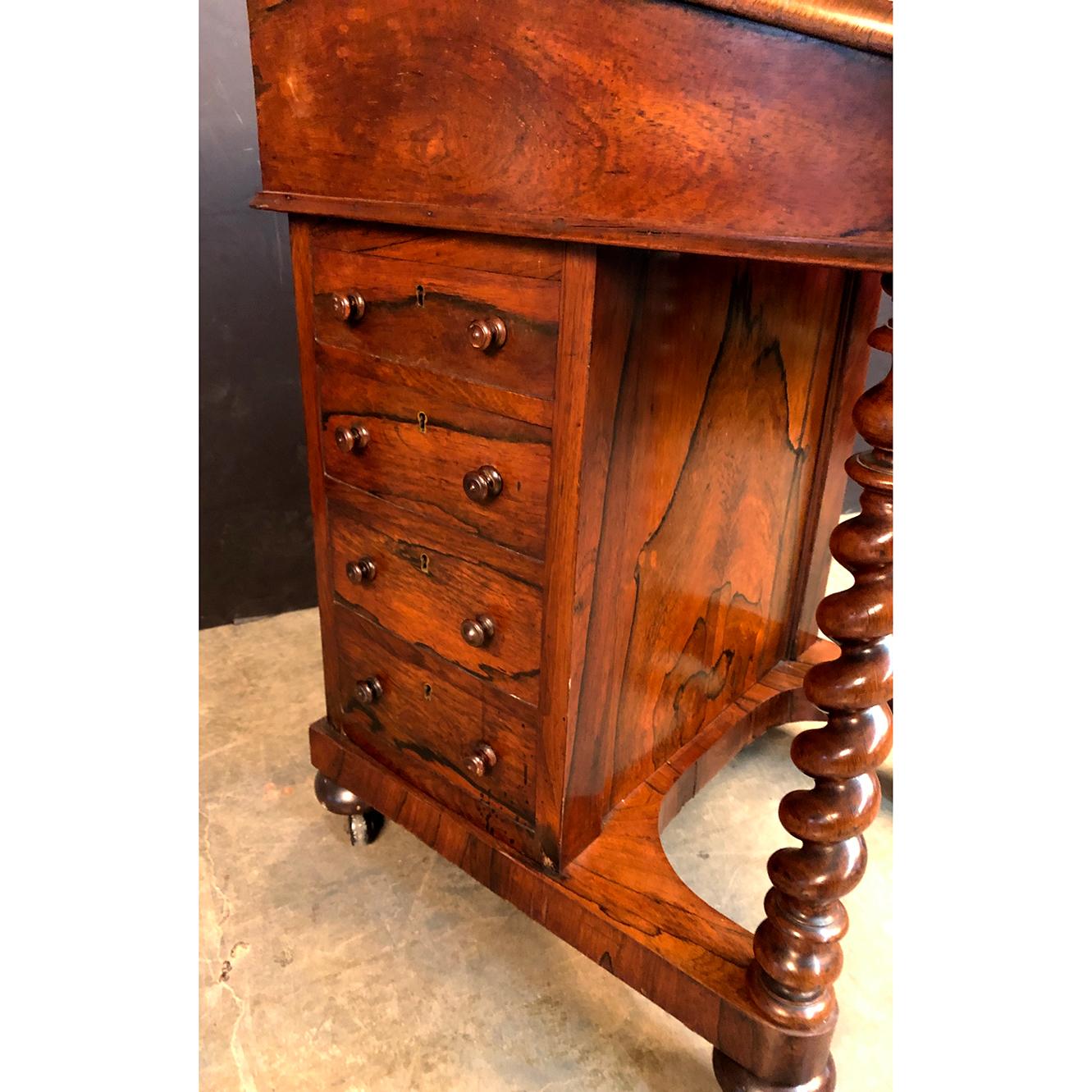 A late Regency rosewood leather top Davedort standing desk with a lift top opening to a fitted satinwood interior, with a secret release to the figured hidden side drawer, a pierced bronze three-quarter gallery, barley twist carved supports, drawers