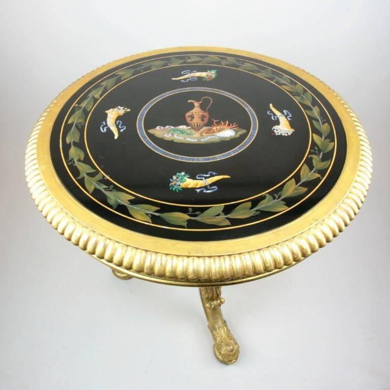 A very attractive antique late Regency giltwood centre table attributed to Gillow of Lancaster and London, inset with an Italian Pietra Dura top, 

The central turned baluster supported on tripod feet, carved in high relief with acanthus leaves