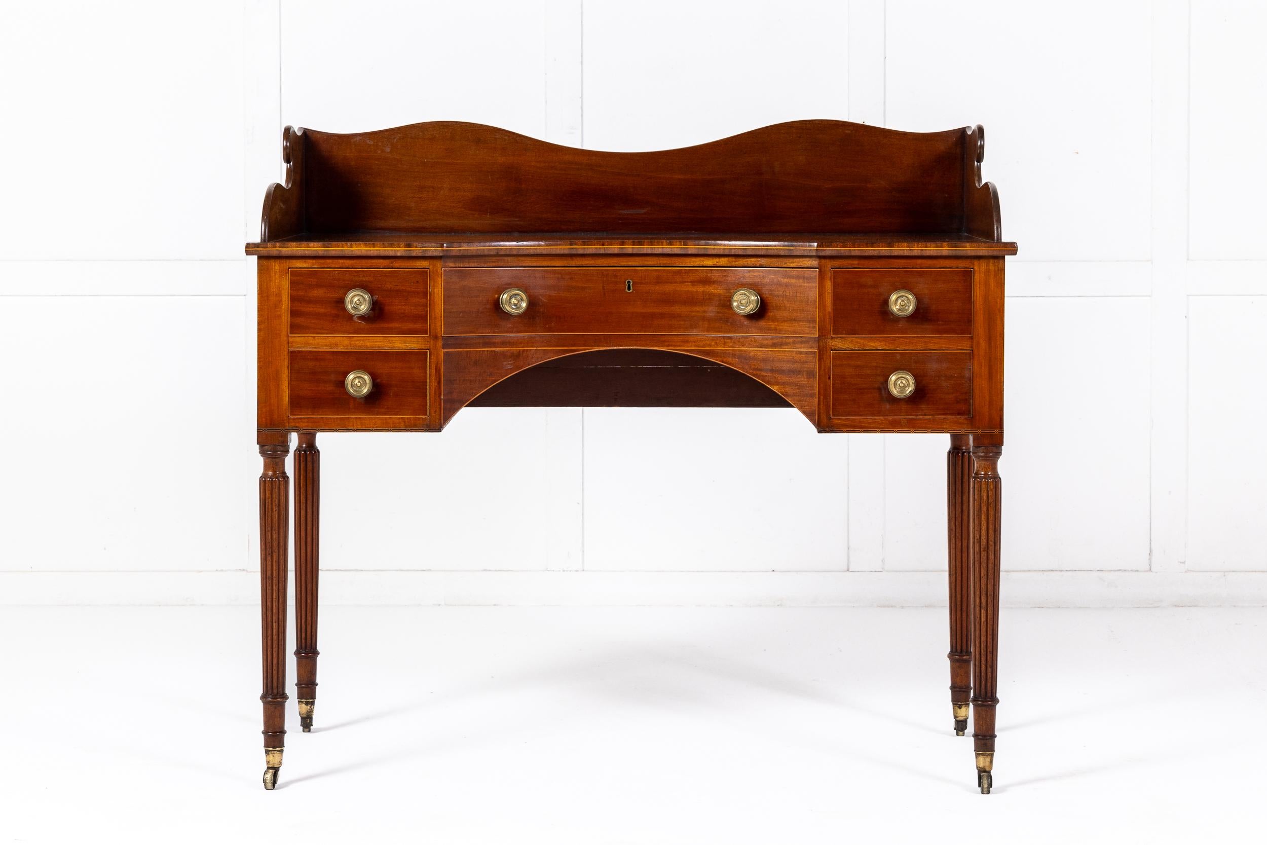 A Fine Late Regency Mahogany Dressing or Writing Table in the Manner of Gillows of Lancaster.

This fine table with its shaped superstructure and concave front was originally conceived as a dressing table but today such pieces are often used as