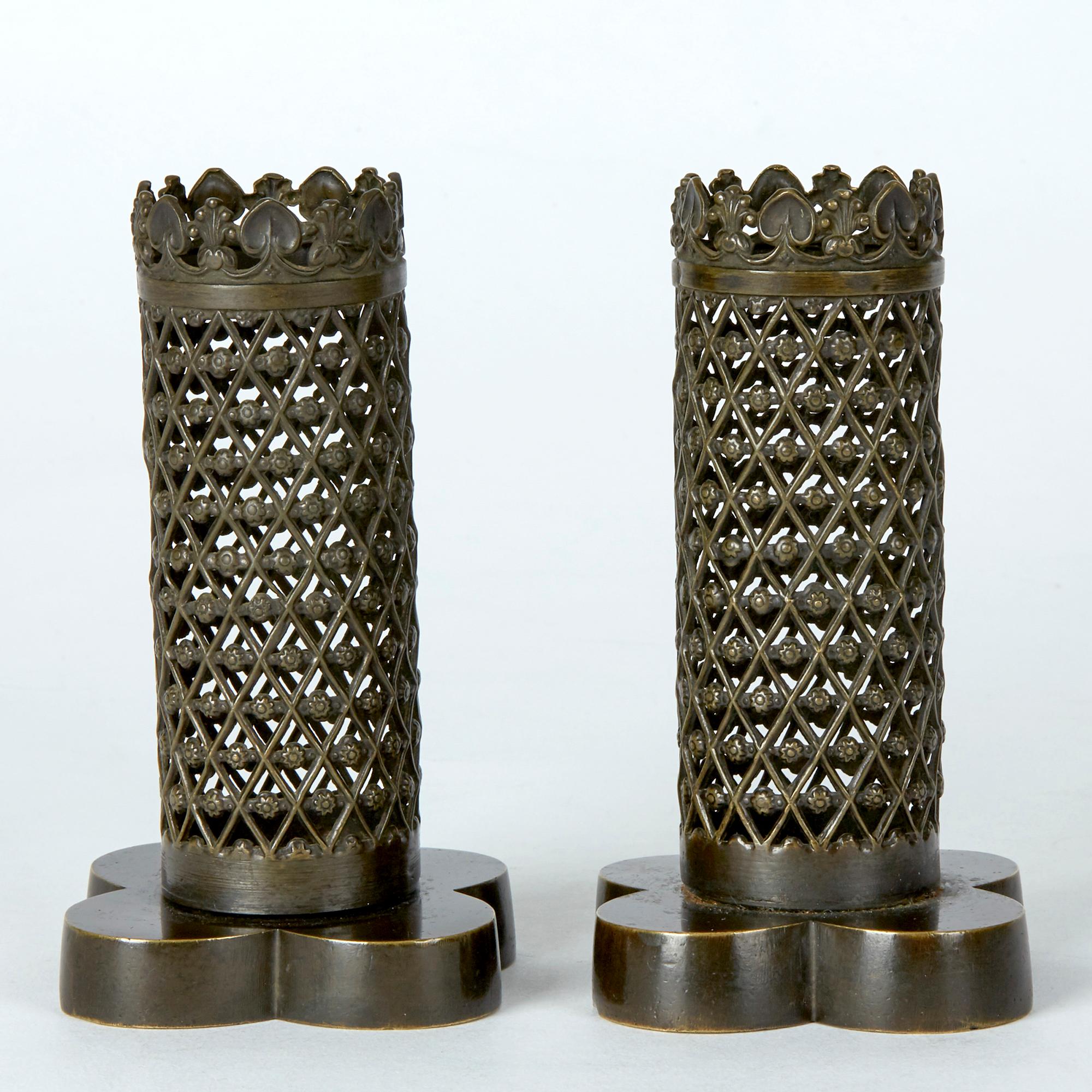 A rare and unusual pair quality late Regency period open work spill vases of Gothic style cast in bronze dating from circa 1820. The spill vases are supported on a weighted quatrefoil base with open trellis work spill holders with a castellated top