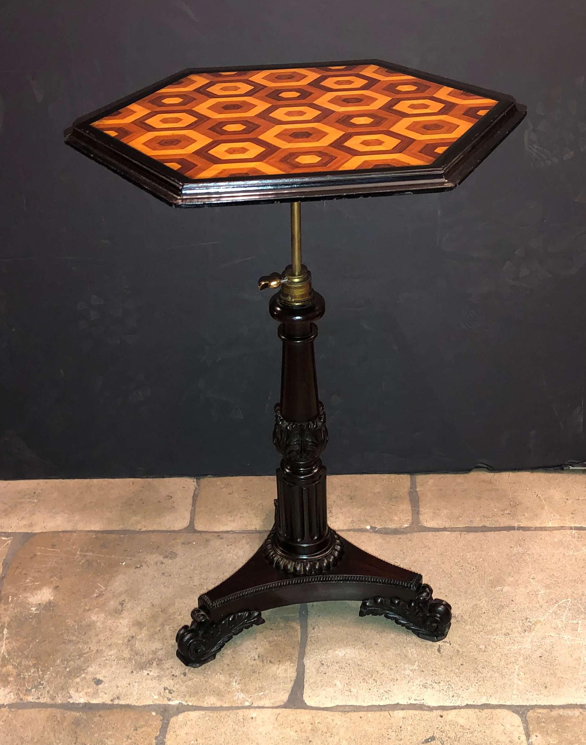 Late Regency adjustable height stand with a parquetry inlaid hexagonal top, brass adjustable supports on a carved acanthus wrapped winged foot tripartite base.